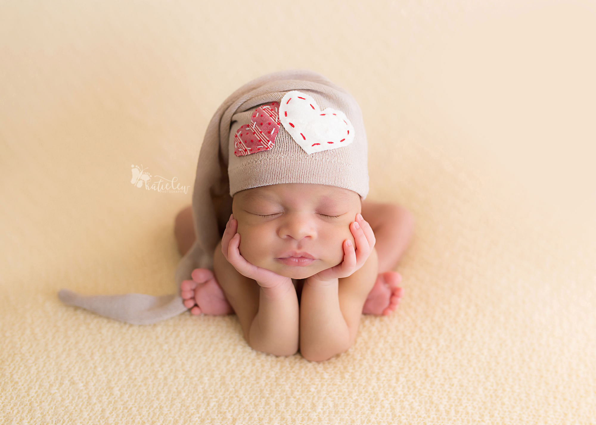 froggy pose with baby girl wearing a heart hat