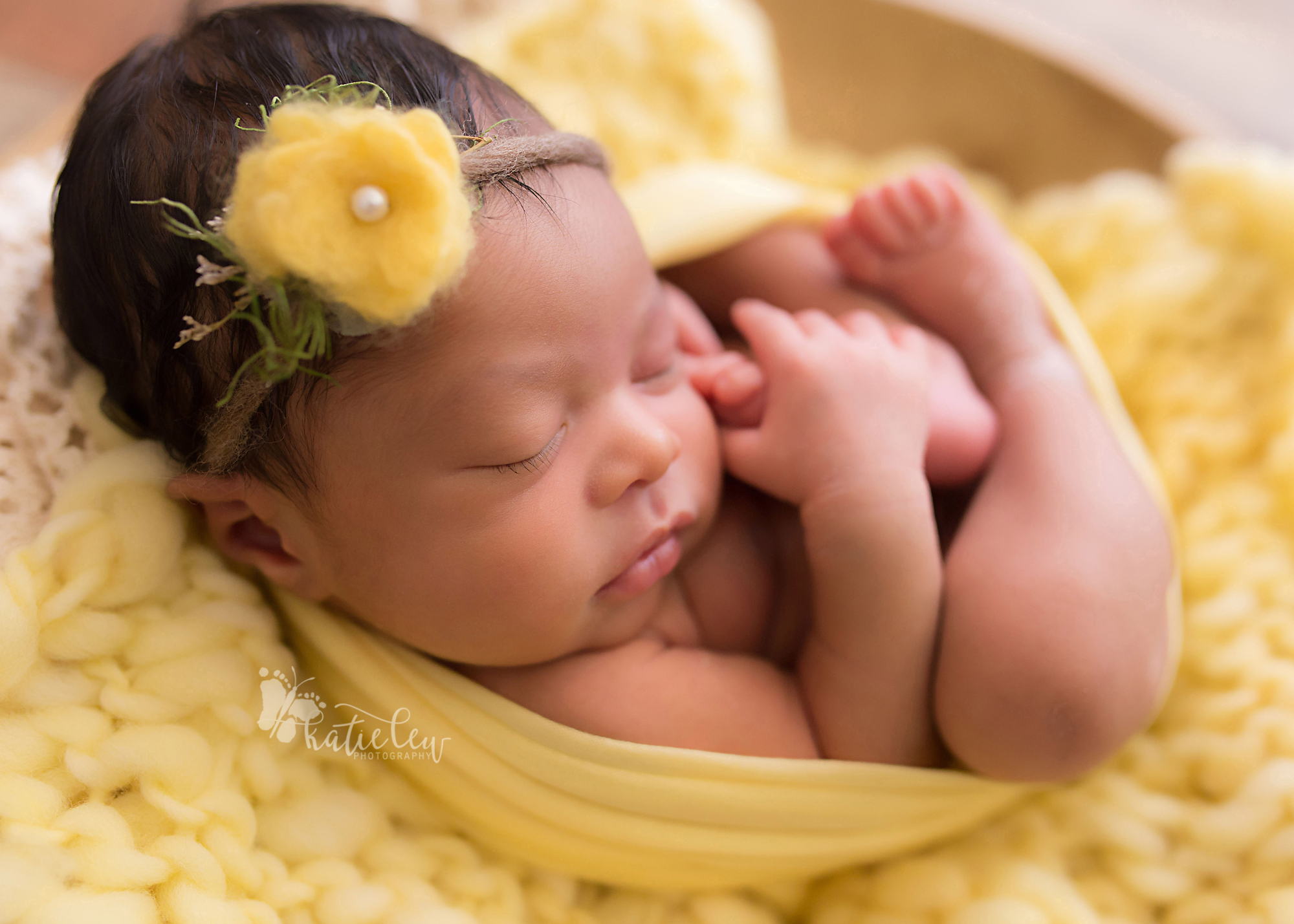 newborn baby girl wrapped in yellow