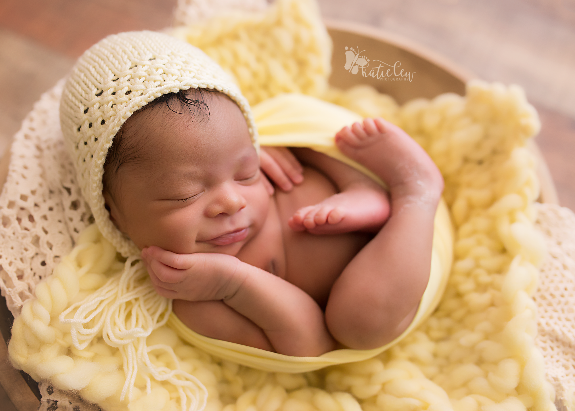 sweet smiling baby girl wearing a yellow bonnet