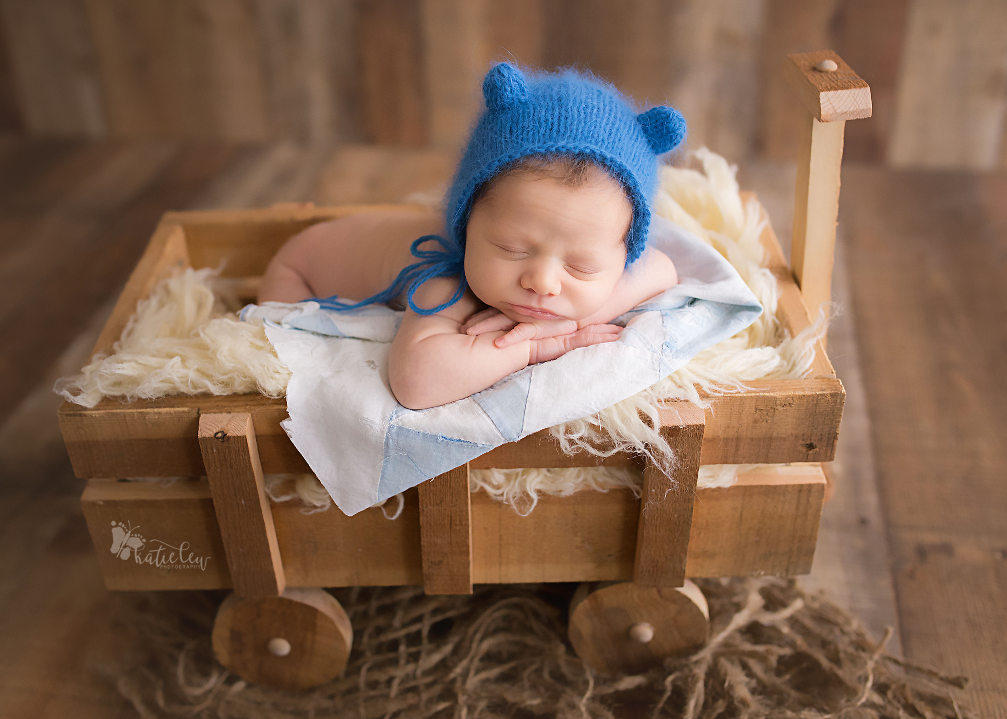 A newborn boy wearing a blue bear hat