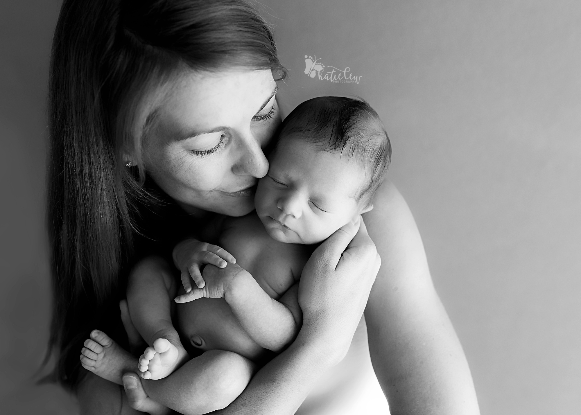 Mother holding and snuggling her newborn son