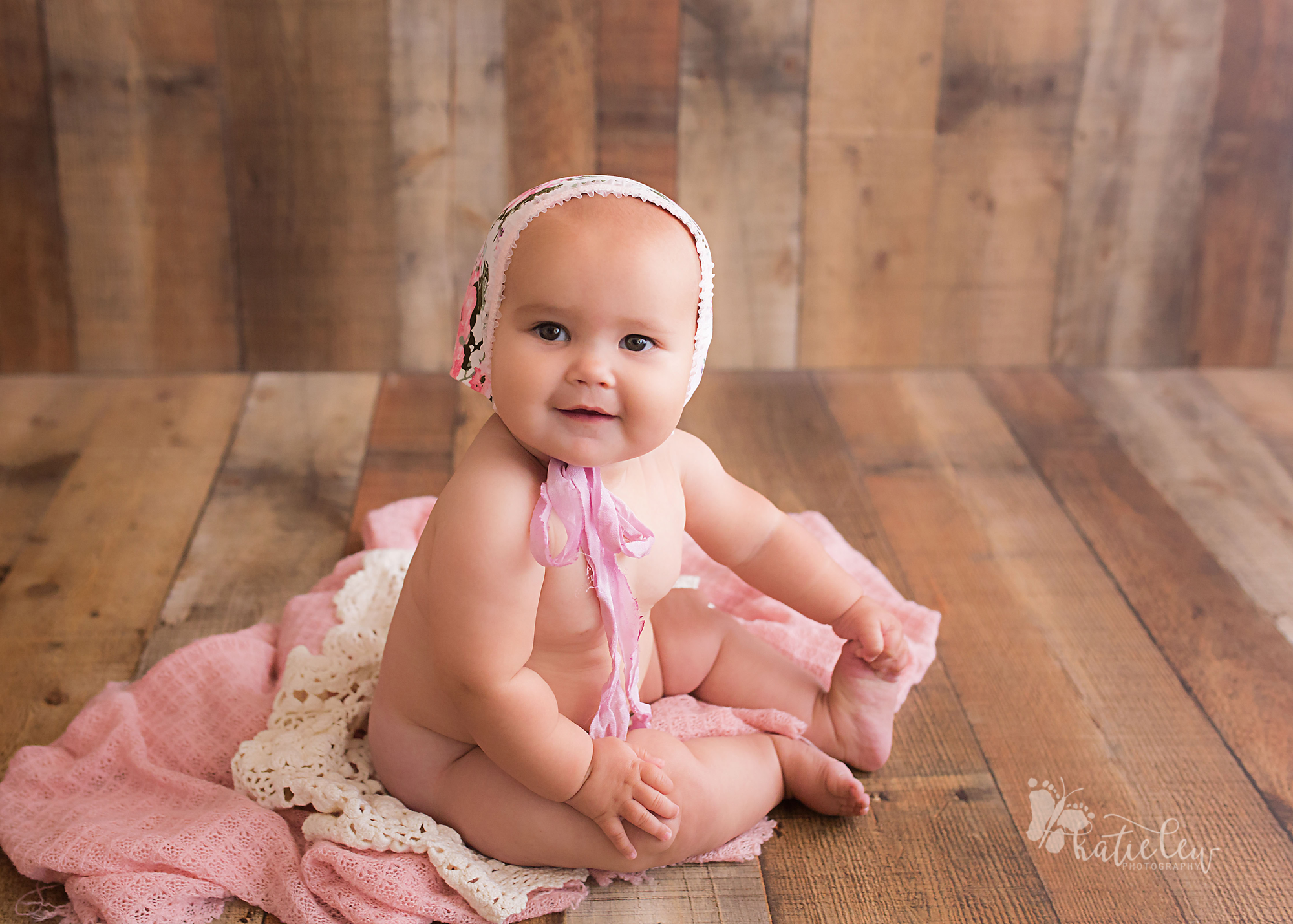 6 month baby naked except for a cute floral bonnet