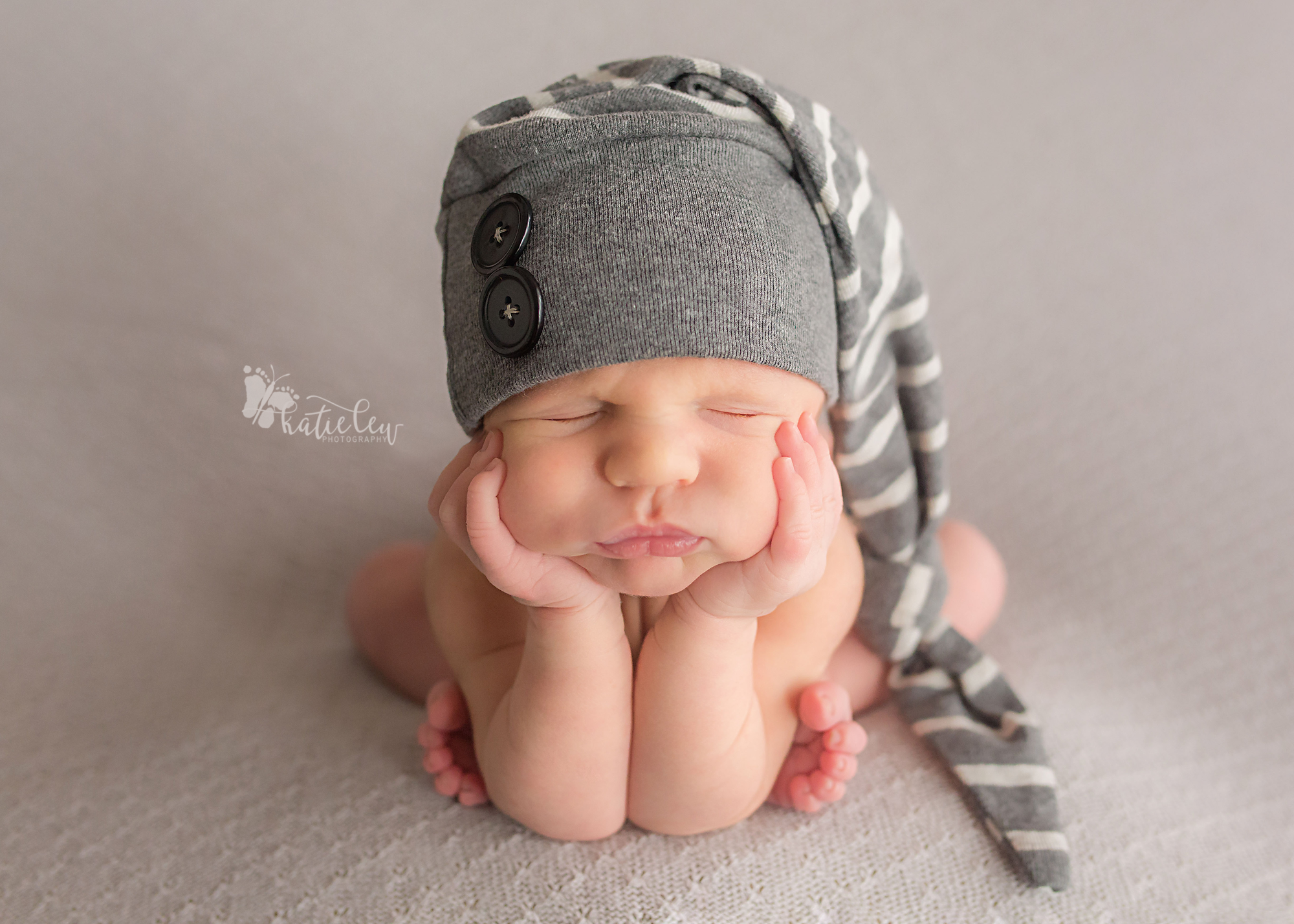 newborn baby boy wearing a striped hat