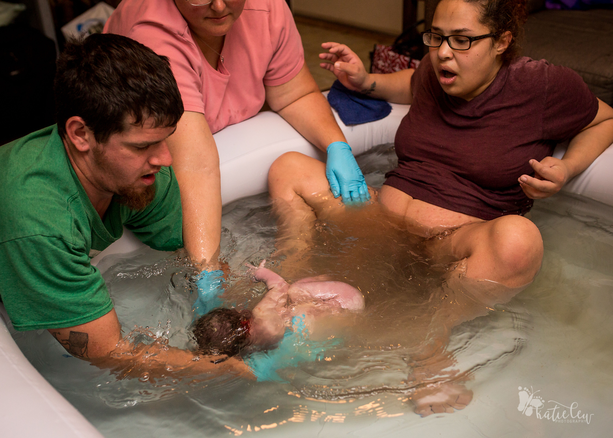 dad pulls baby out of the water at home birth