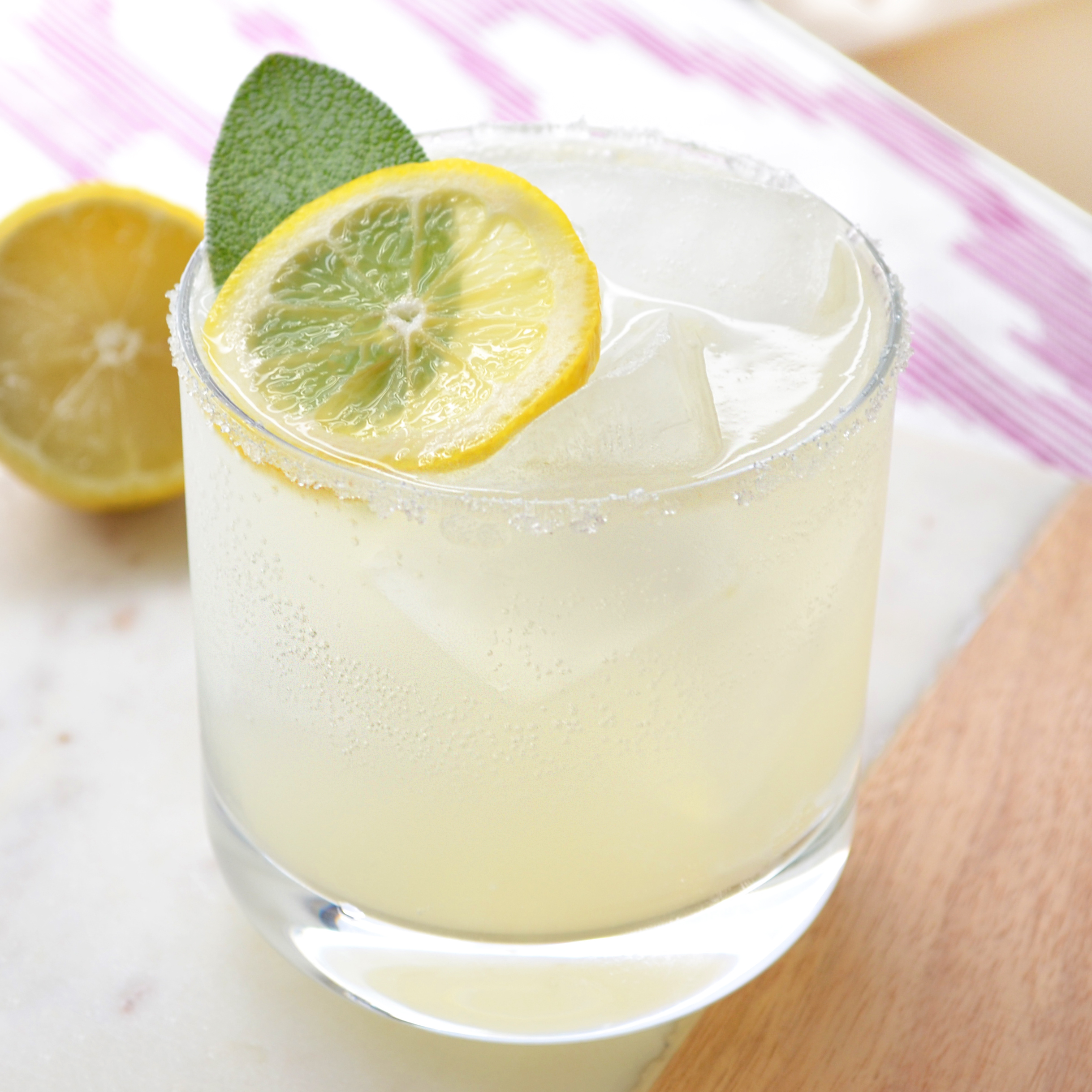 Adults' Only Lemonade 1.5 oz vodka 1 oz sweet and sour 1/2 lemon, freshly-squeezed ½ oz maple simple syrup Lemon sparkling water Sugar for rim Lemon slice and sage leaf for garnish