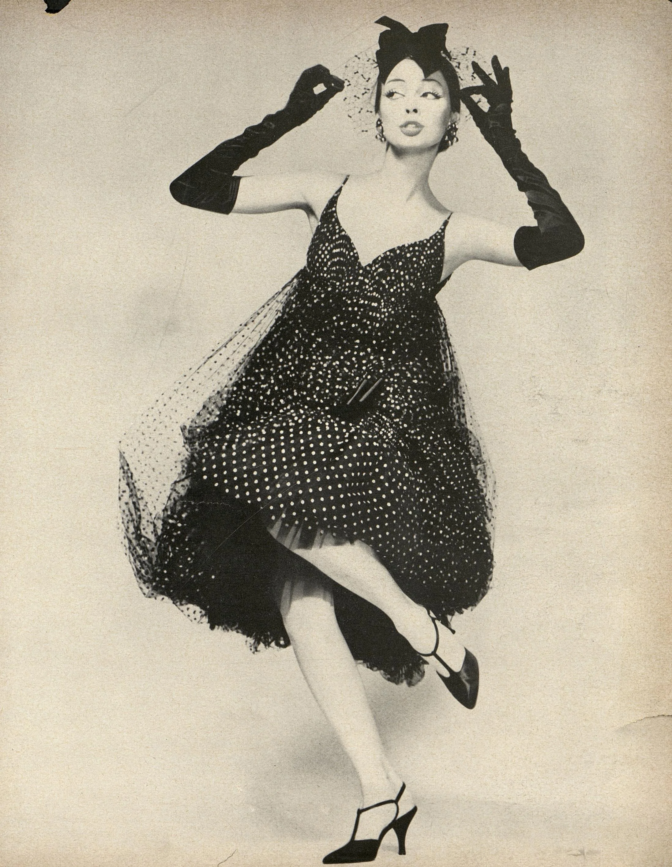 “This enchantment is made of coppery-dotted black point d’esprit, billowed from a point just below the bosom into a great, blown skirt that’s caught above the knee with a satin bow, then released into a deep flounce.” Photographed by Richard Avedon for Harper’s Bazaar, February 1958.