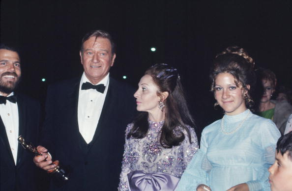 John Wayne with his sparkling lavender wife, Pilar, and daughter at the Academy Awards after winning the best actor Oscar for True Grit on April 7, 1970 in Los Angeles.