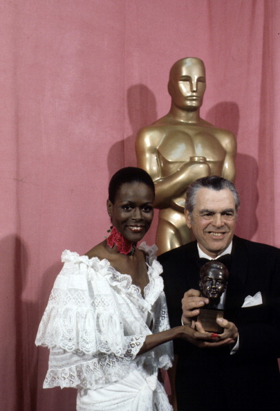 In a riot of white lace with a red flower choker, Cicely Tyson presenting Pandro Berman with his Irving G. Thalberg Memorial Award at the 49th Annual Academy Awards, on March 28, 1977.