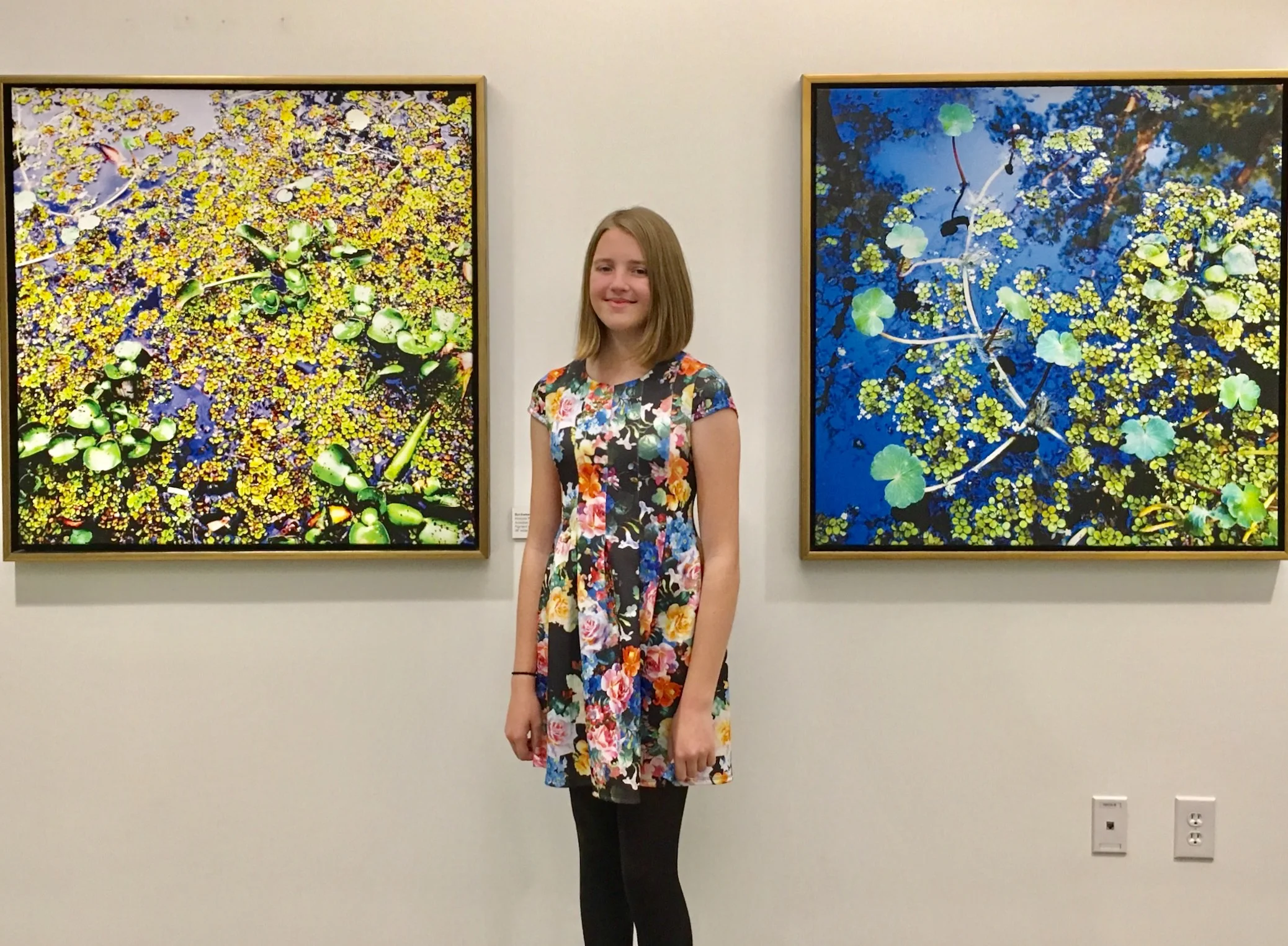 Young environmentalist Isabelle Pierson at The Collider with (at left) Duckweed #1, 2008 (38" x 38" framed) and Duckweed #4, 2009 (38" x 38" framed), 