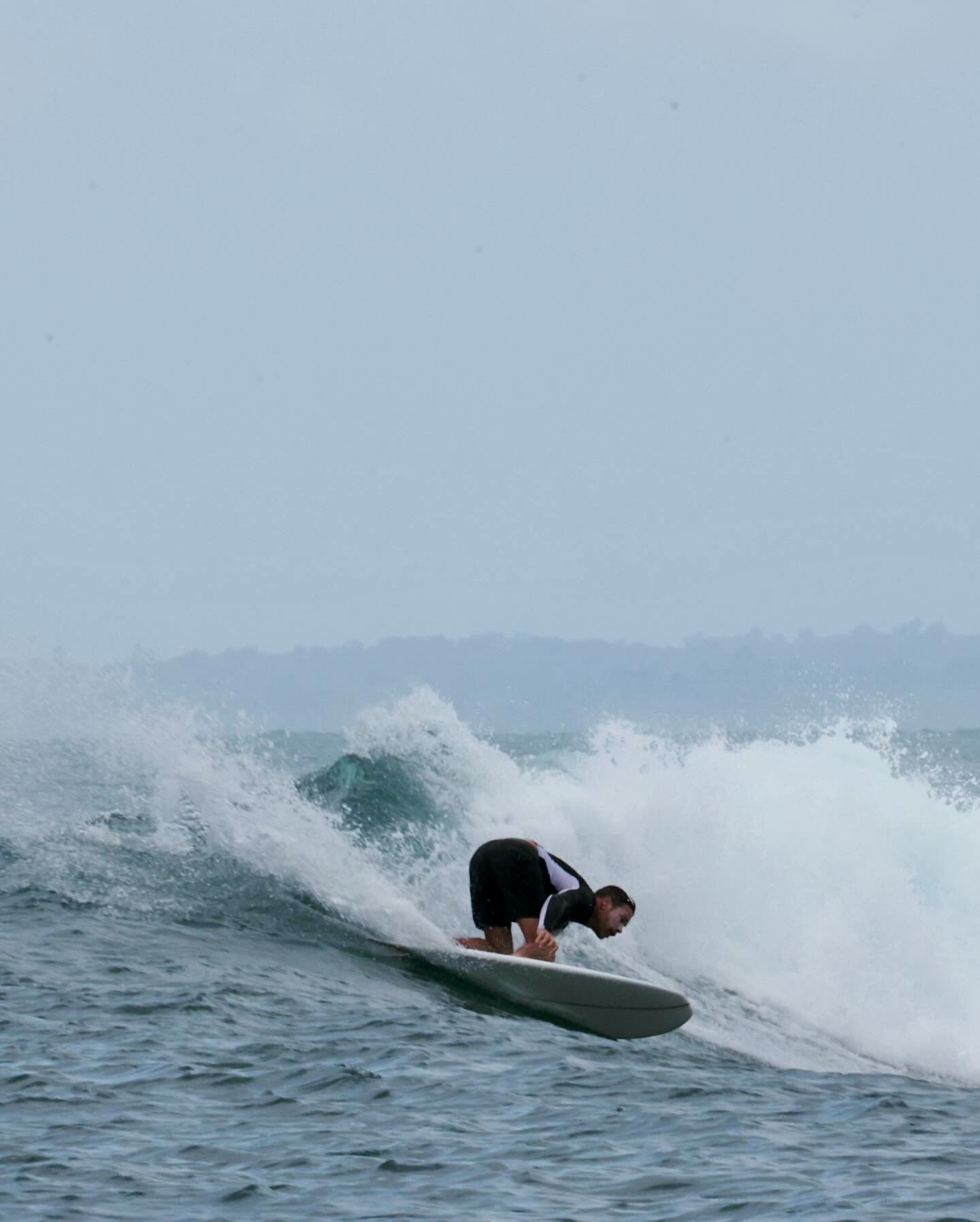 A man in a wetsuit is riding a wave on a surfboard in the ocean.