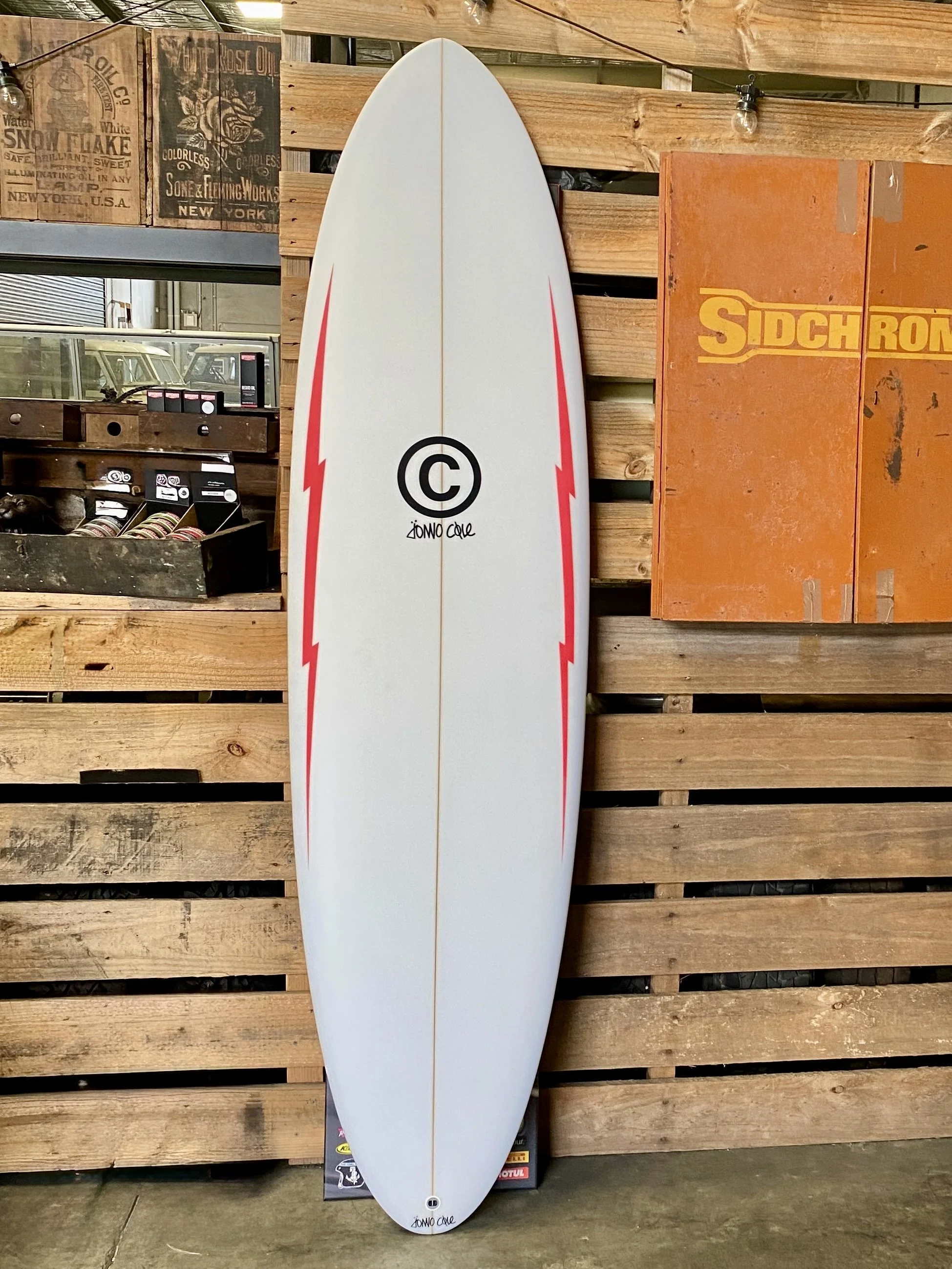 White surfboard with red lightning bolts down each side
