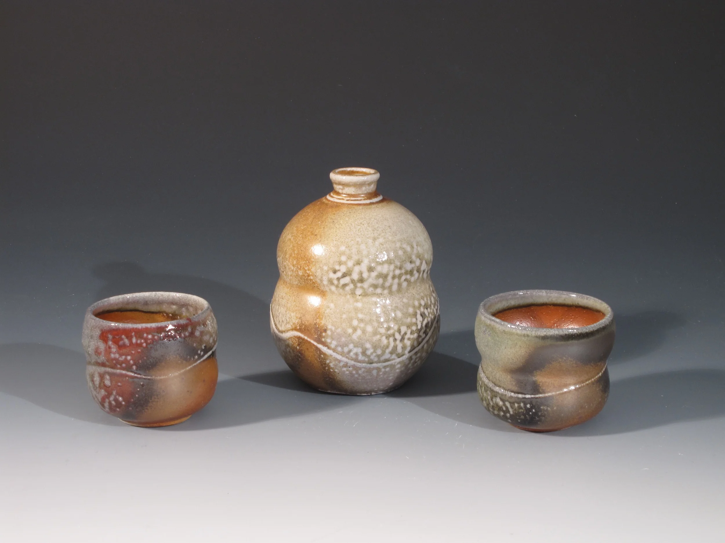 Wood/ soda fired sake bottle and cups. Shino glaze. bottle is 4.5" 