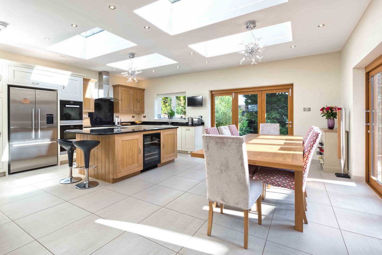 A dining room and kitchen with a skylight of a modern house extension by Harvey Norman Architects St Albans