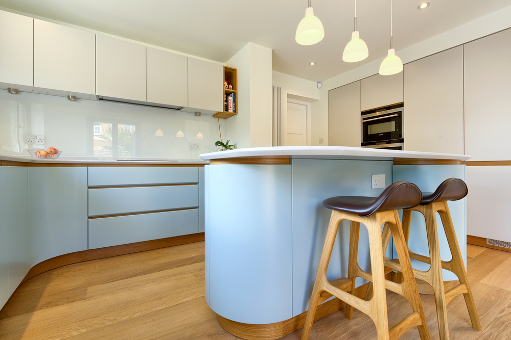 High stools for a breakfast bar of a Scandinavian house extension by Harvey Norman Architects Bishop's Stortford