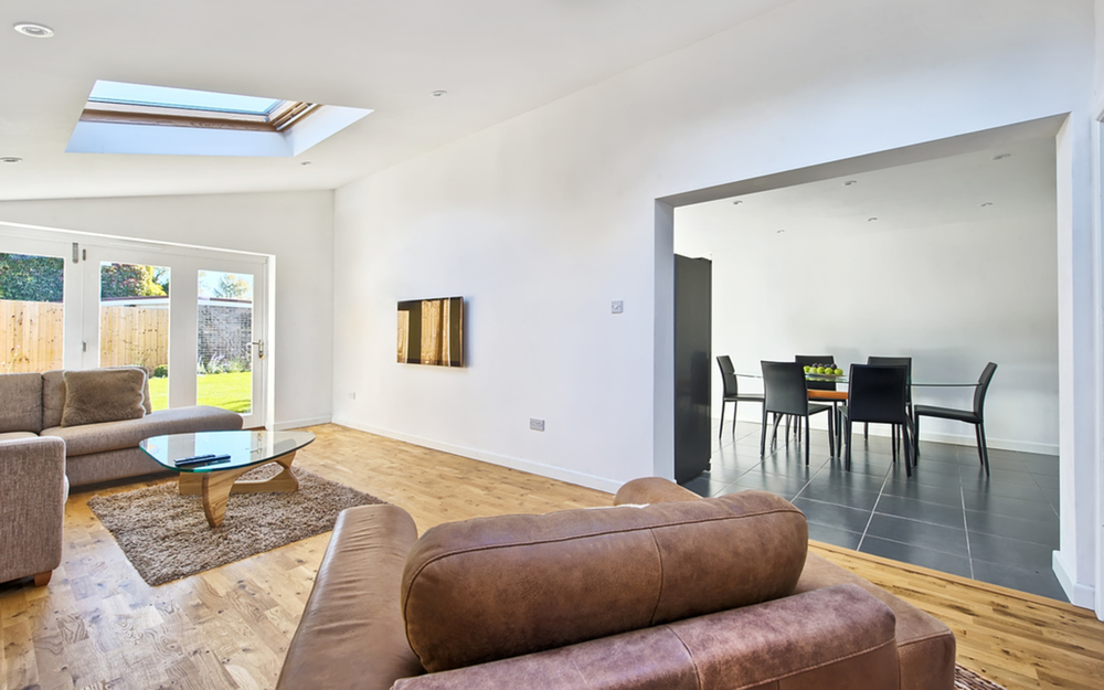 Sitting room view into kitchen and garden of a house extension by Harvey Norman Architects Cambridge