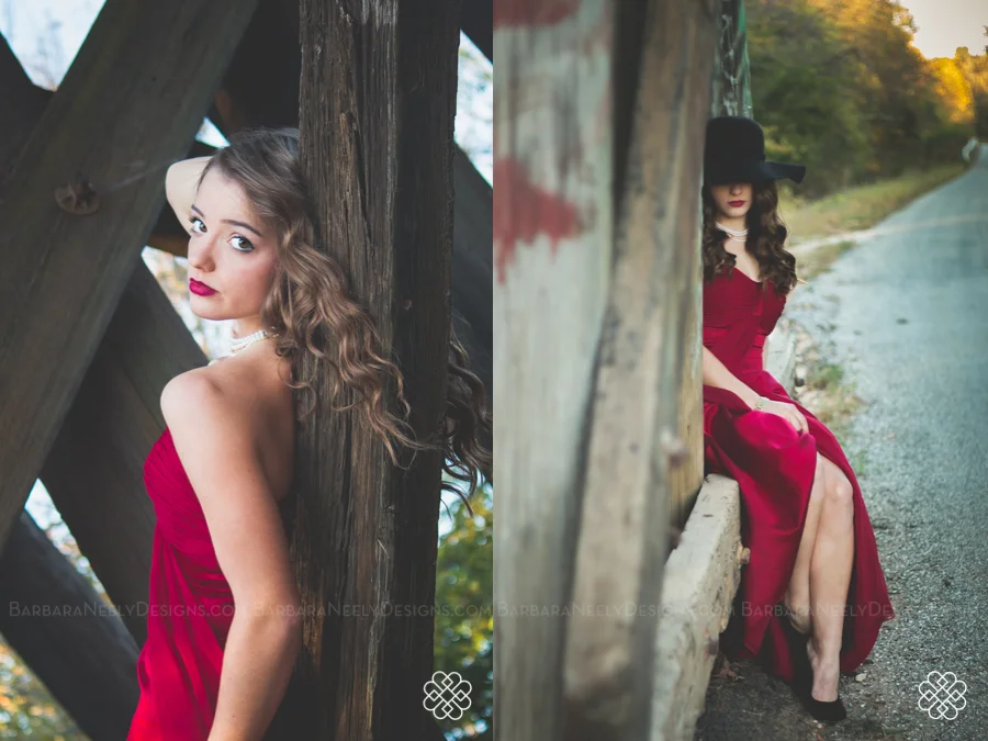 Very dramatic senior girl in red prom dress on railroad truss