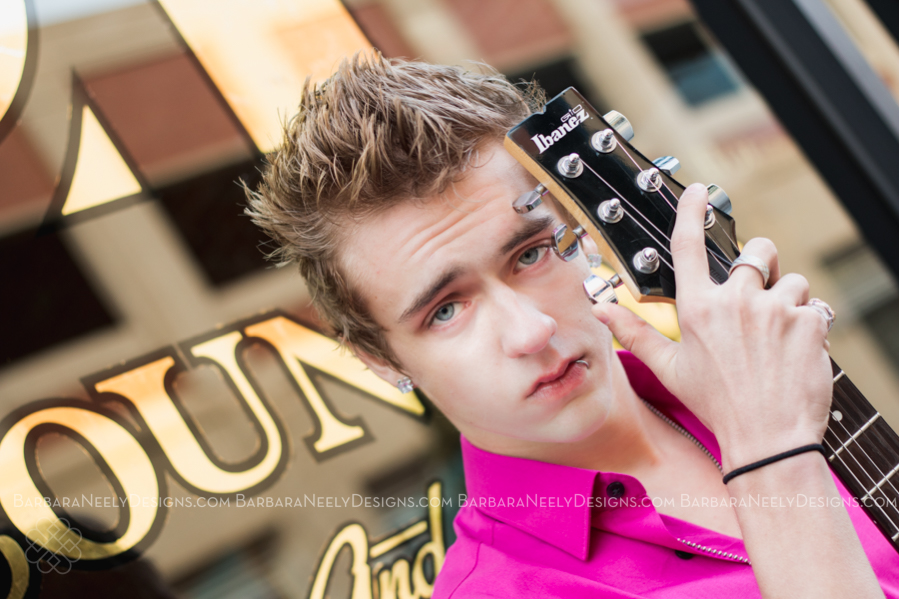Senior guy on city street with guitar
