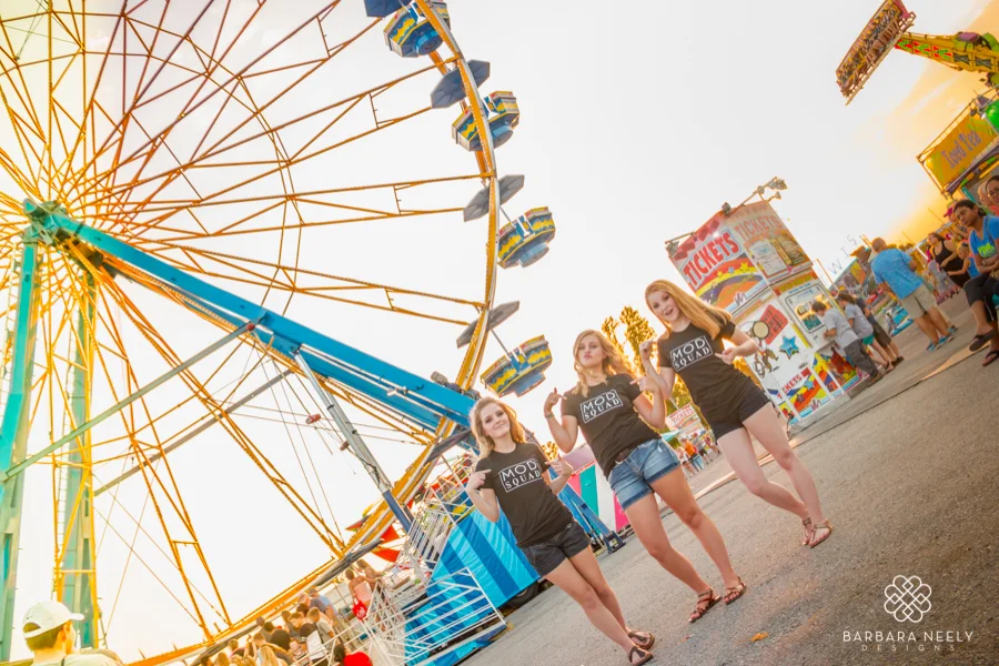 Senior girl group session at the fair in front of a ferris wheel