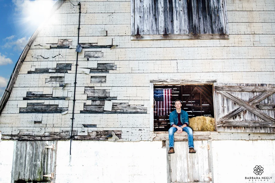 Senior guy hanging out in a barn loft with American flag
