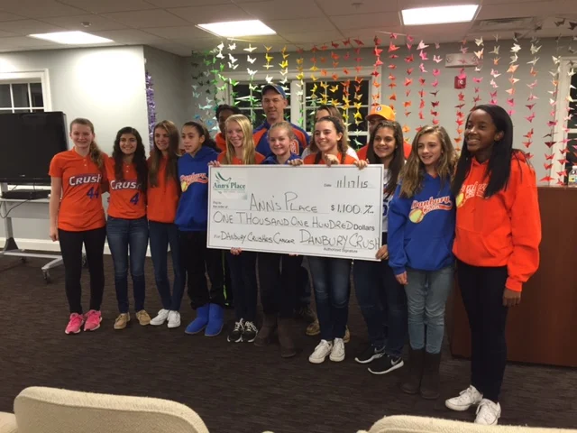 Danbury Crush 14 U fast pitch softball team presents a check to Ann's Place