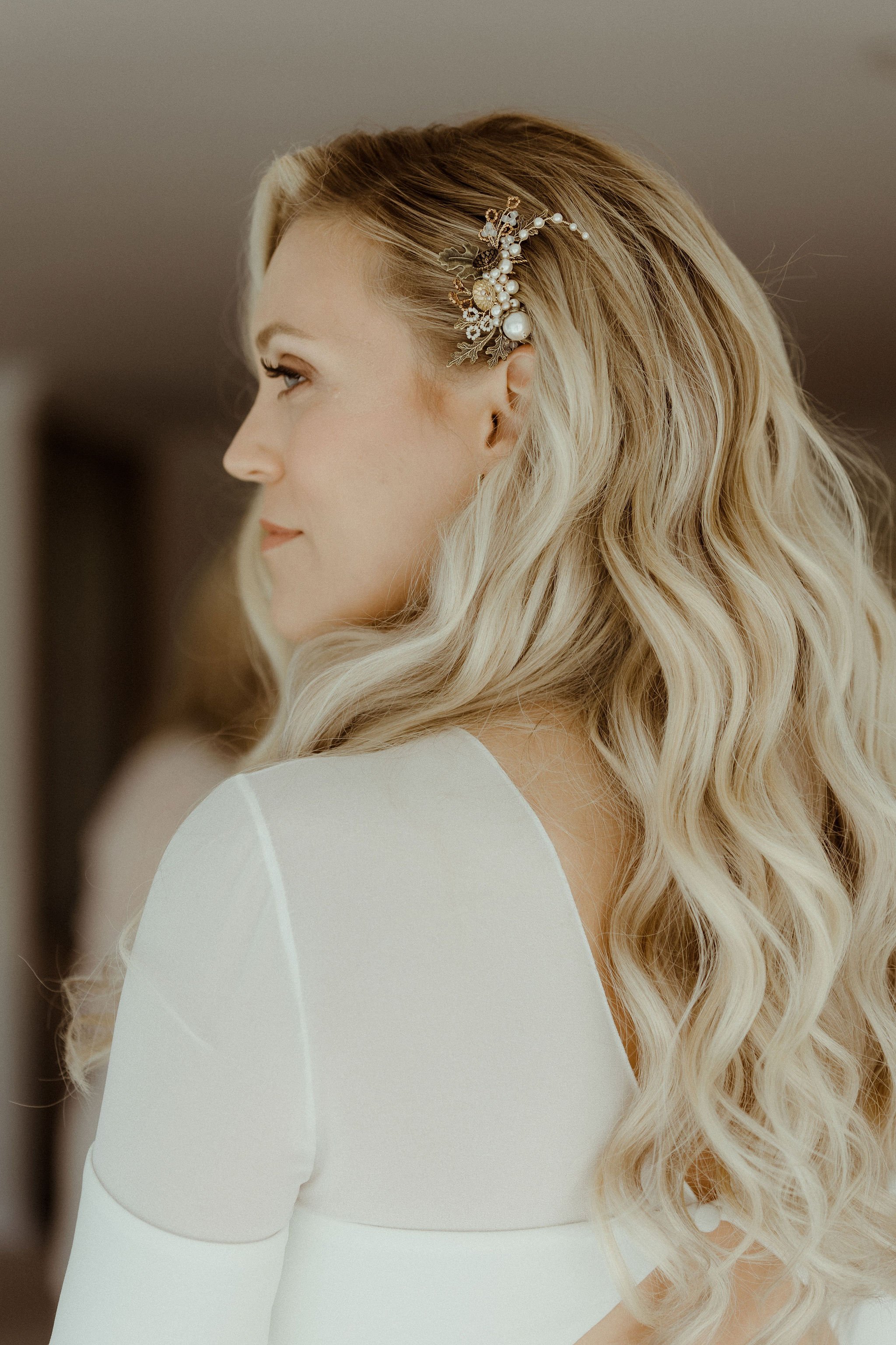 Elegant wavy hair style with delicate hair slide on one side 