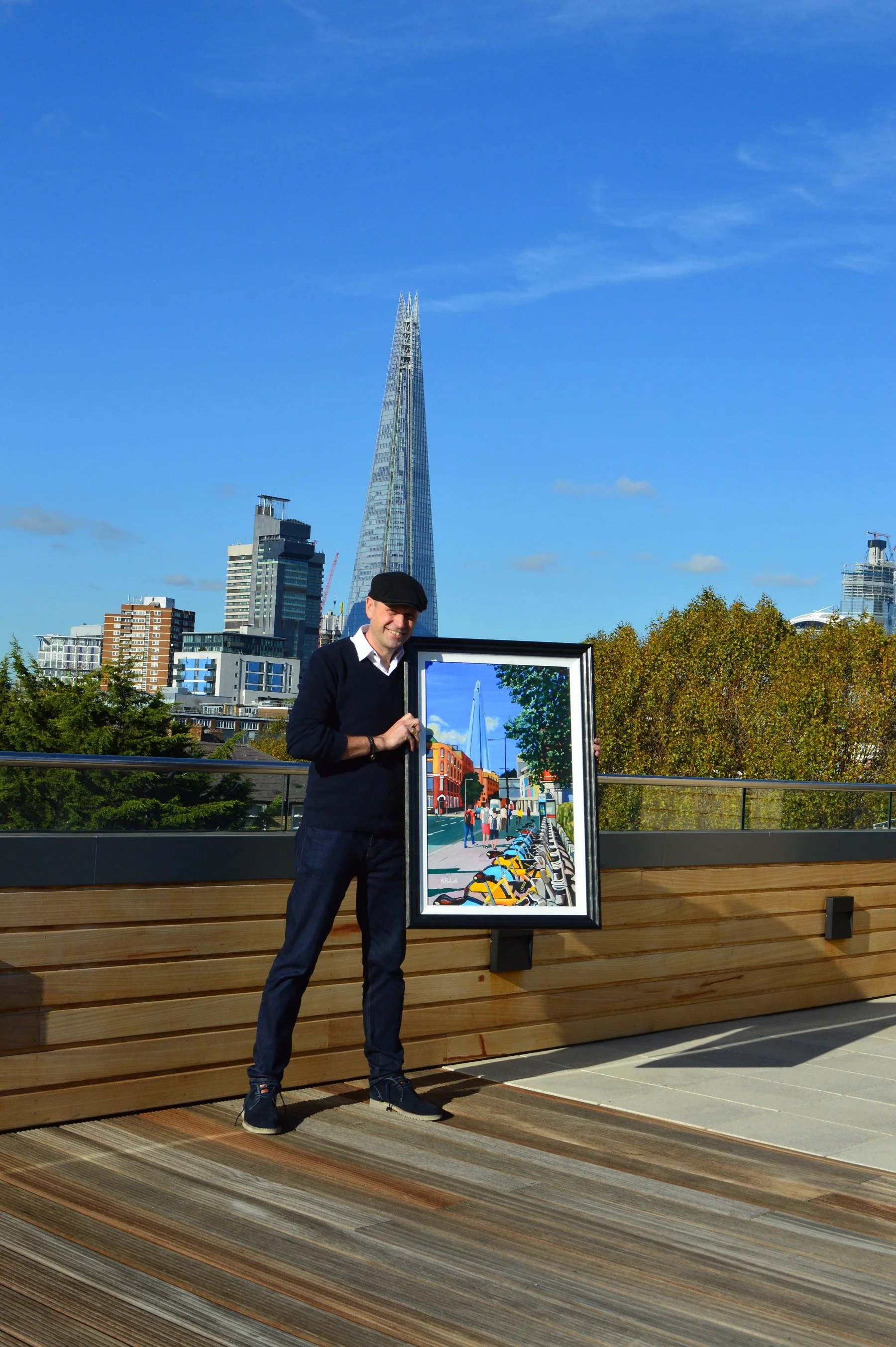 Artist Holding up Framed Shard Painting.