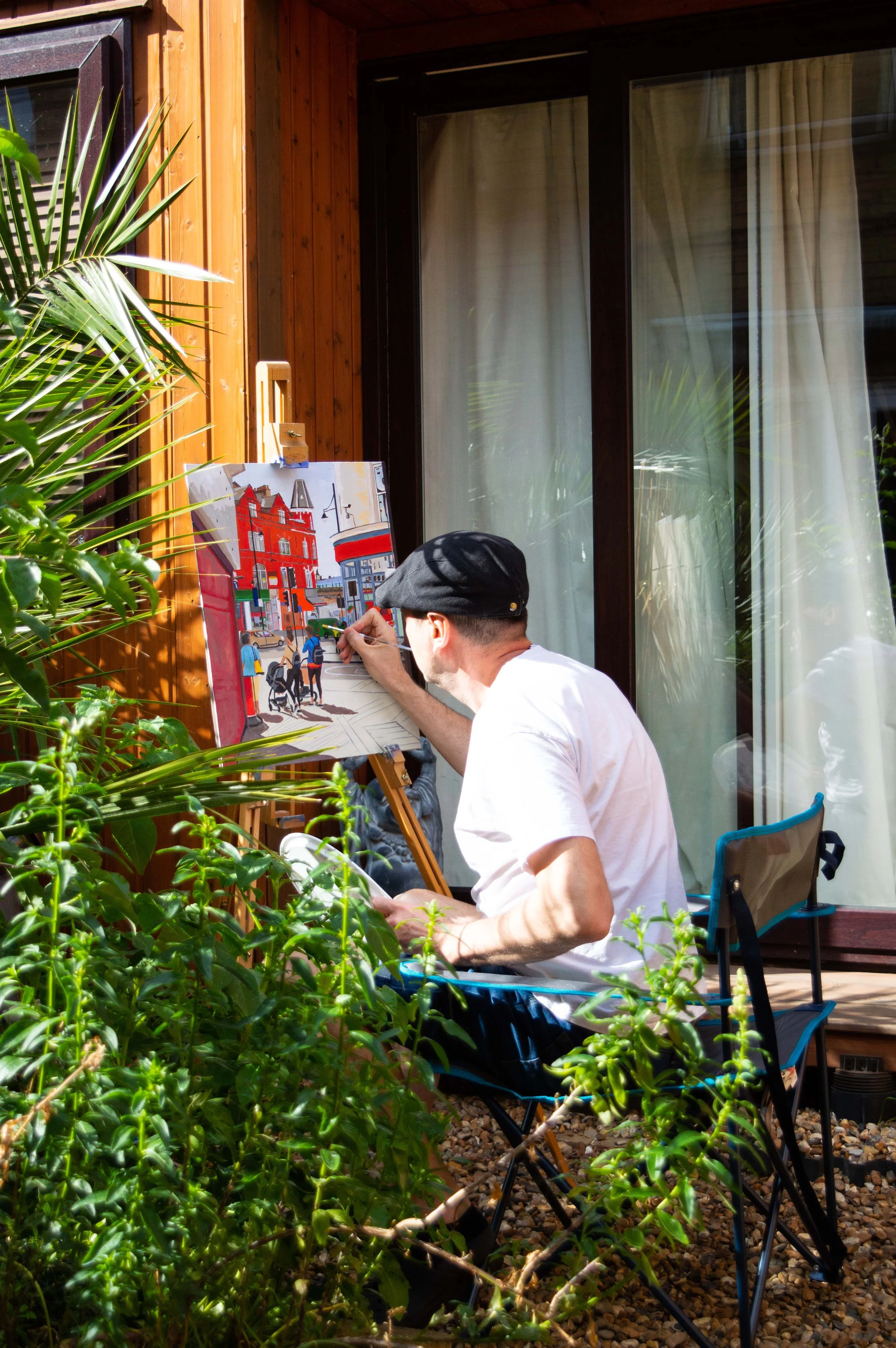 London artist Magnus Rodwell painting with the easel in the garden.