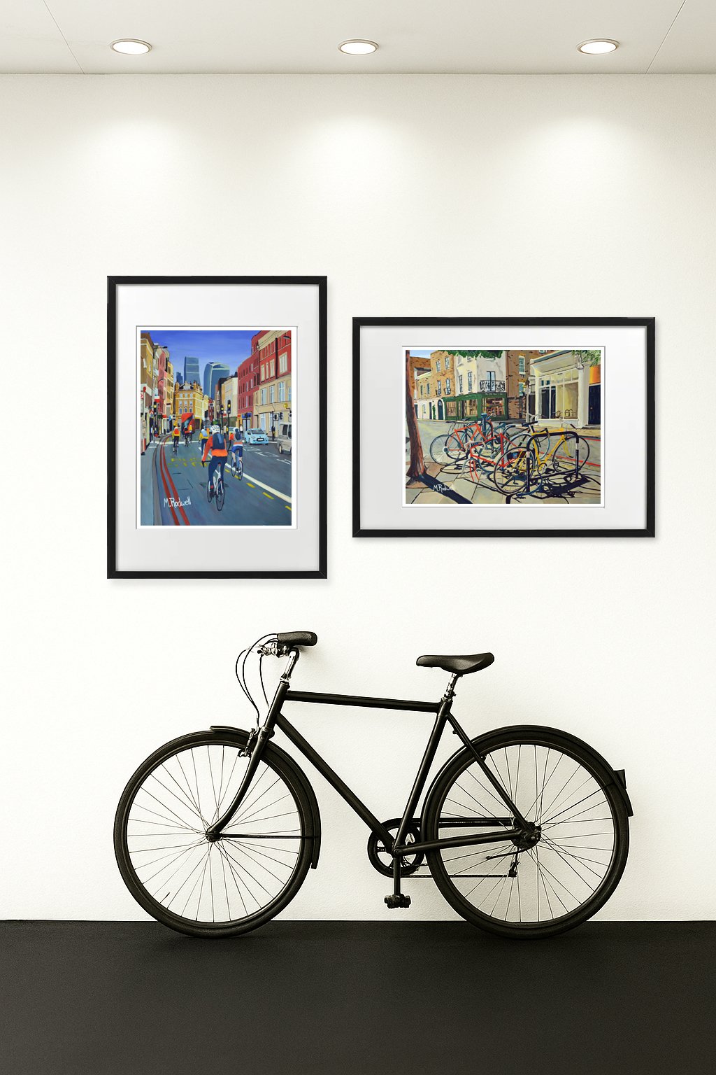 Impressionist artwork on display in a room with bicycle.  Artwork featuring cyclists and bicycles in London