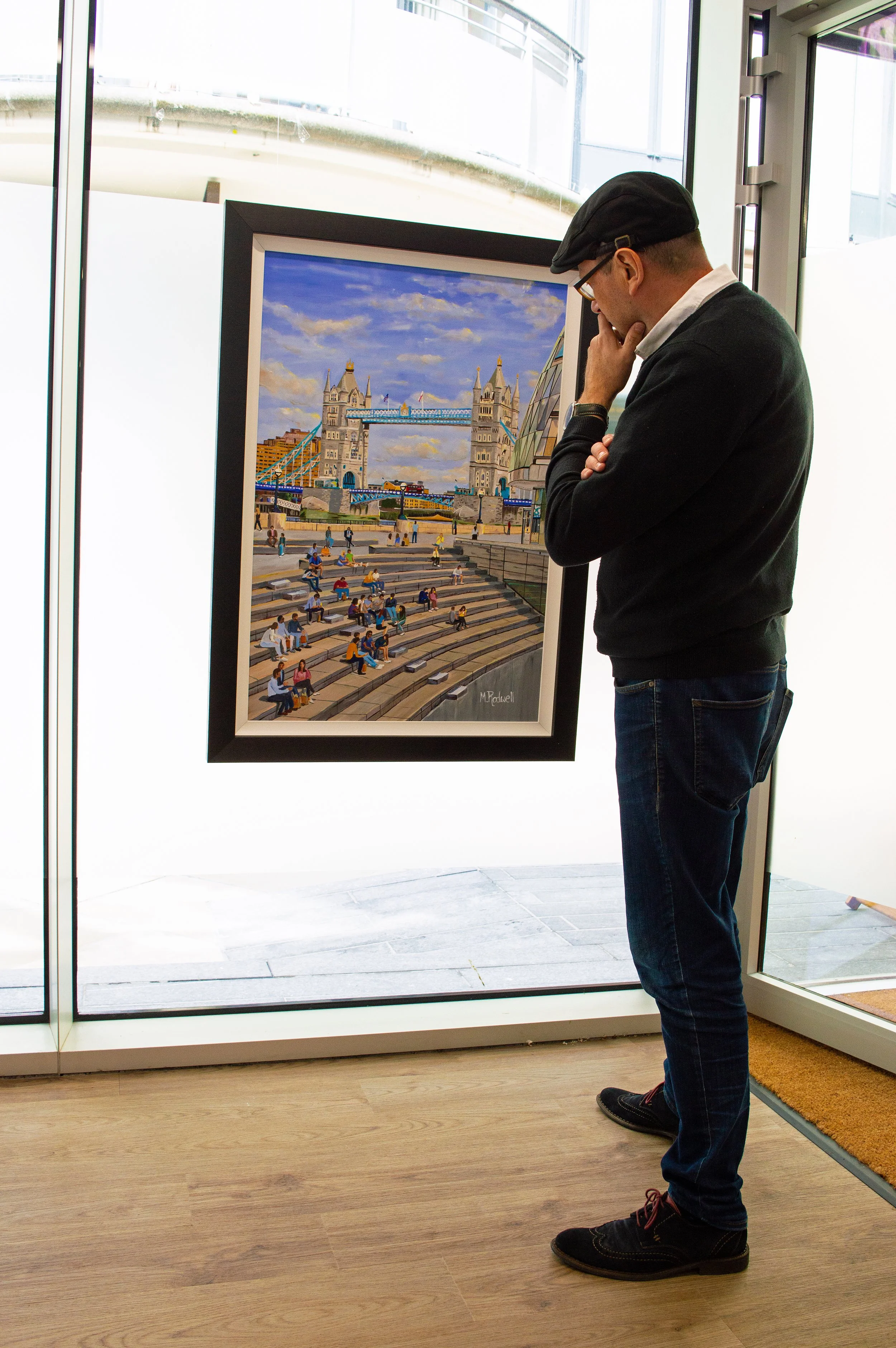 London Artist M.Rodwell admiring fine art, framed acrylic painting of Tower Bridge and the Scoop.  Displayed in a London Gallery.