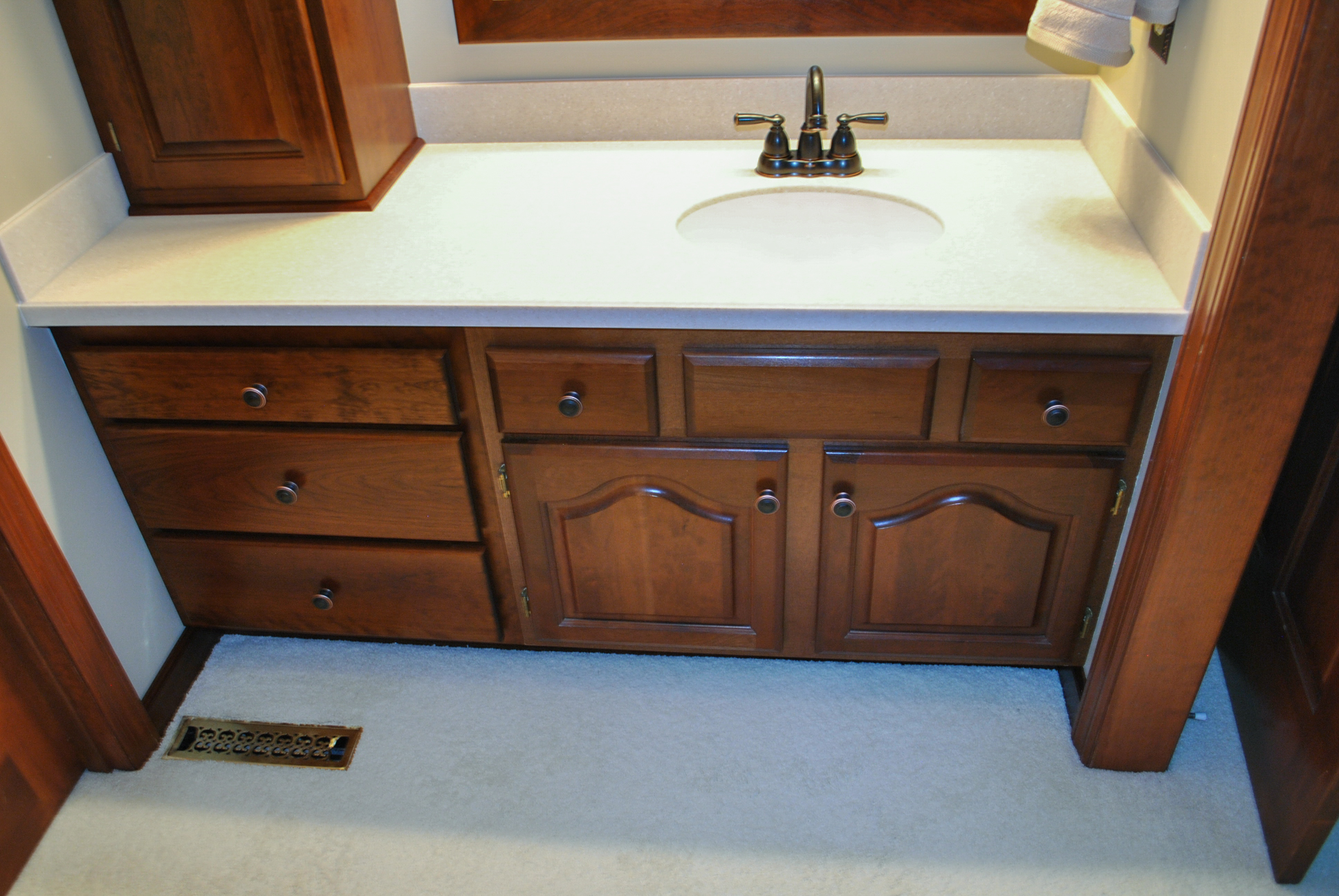 We replaced the existing single drawer at left with a three drawer cabinet. We also fabricated a new solid surface counter top with an under-mount sink.