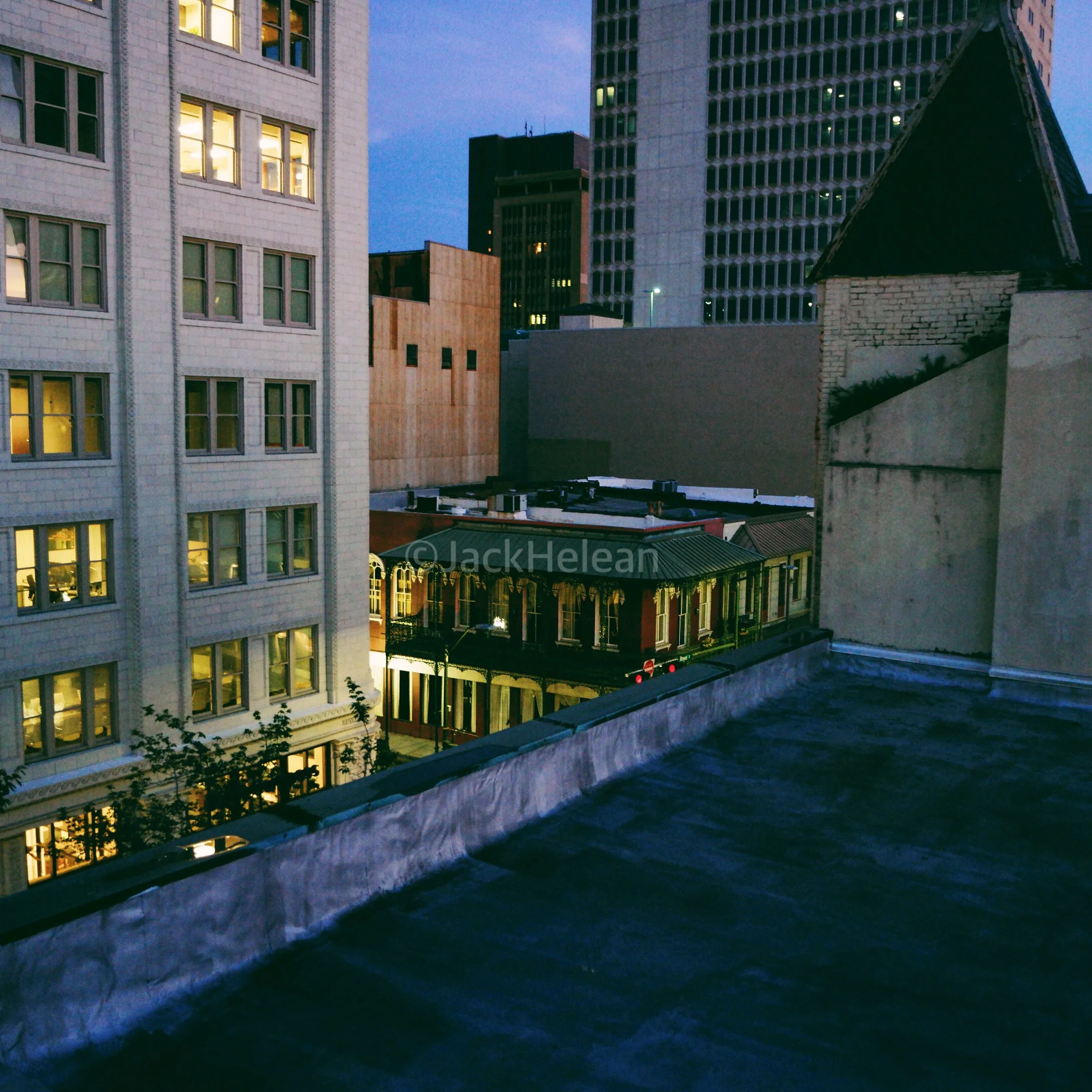 Looking down on a 19th century building squished between the skyscrapers.