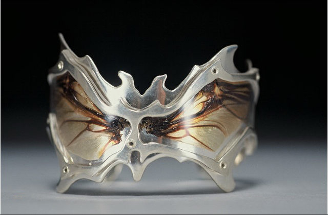Winged Cuff: 2003 I'd been doing a lot of research on how insects were represented in traditional jewelry, and was currently doing a series on scarabs and their status in ancient cultures. At CCA, into the third year, JMA students endure one of the most exhausting classes: a project a week for 8 weeks. This was one of the last pieces I created in that class, learning how to heat and bend plastics (which was an endeavor of my own, most the teachers had zero advice for plastics), form the delicate wings into a curve, and creating my first polished and highly wearable piece. I have made a few similar cuffs since, but I will always keep this one as a reminder of the turning point in my education. 