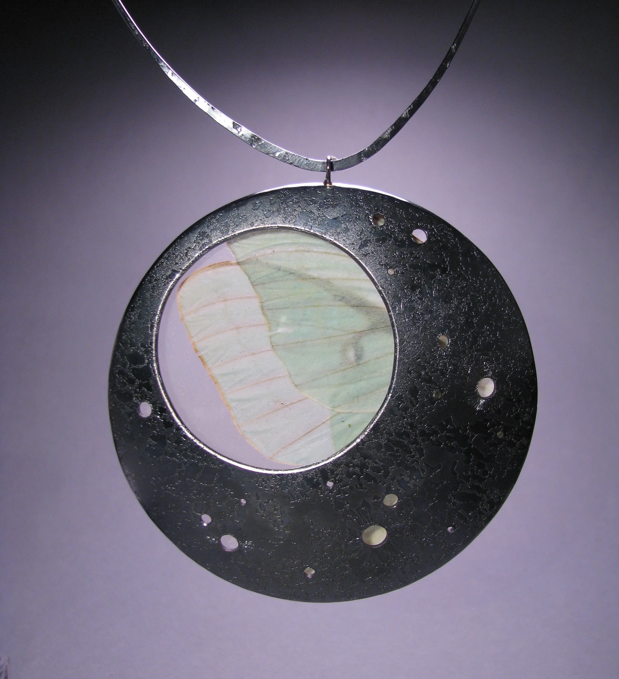 My Moon: 2008 Amongst working full-time for another jewelry designer, I started my first relationship with a gallery, they represented me and started carrying my jewelry, which was a huge step for me. Putting together a new body of work, I returned to one of my tried-and-true themes: lyrical stories and historical references through the use of insects in my jewelry. I love the moth- an often overlooked insect, it's beauty is muted and subtle. "Like a moth to a flame" an expression we often hear, but why is the moth endlessly in love with the flame? Moths instinctively use the moon for their nocturnal navigation, finding their way through the night, and did just fine with this for centuries. Then along come humans, creating first fire, then gas lamps, electricity... we know the rest. It was the first unnatural illuminated objects, and it confuses the moth, instead of being drawn towards the moon, they are now drawn to the flame. A sweet and sad romance story. In this piece, I revisit the story of the moth and the moon, imagining it arriving at it's final destination, finding refuge at it's home for the first time. 