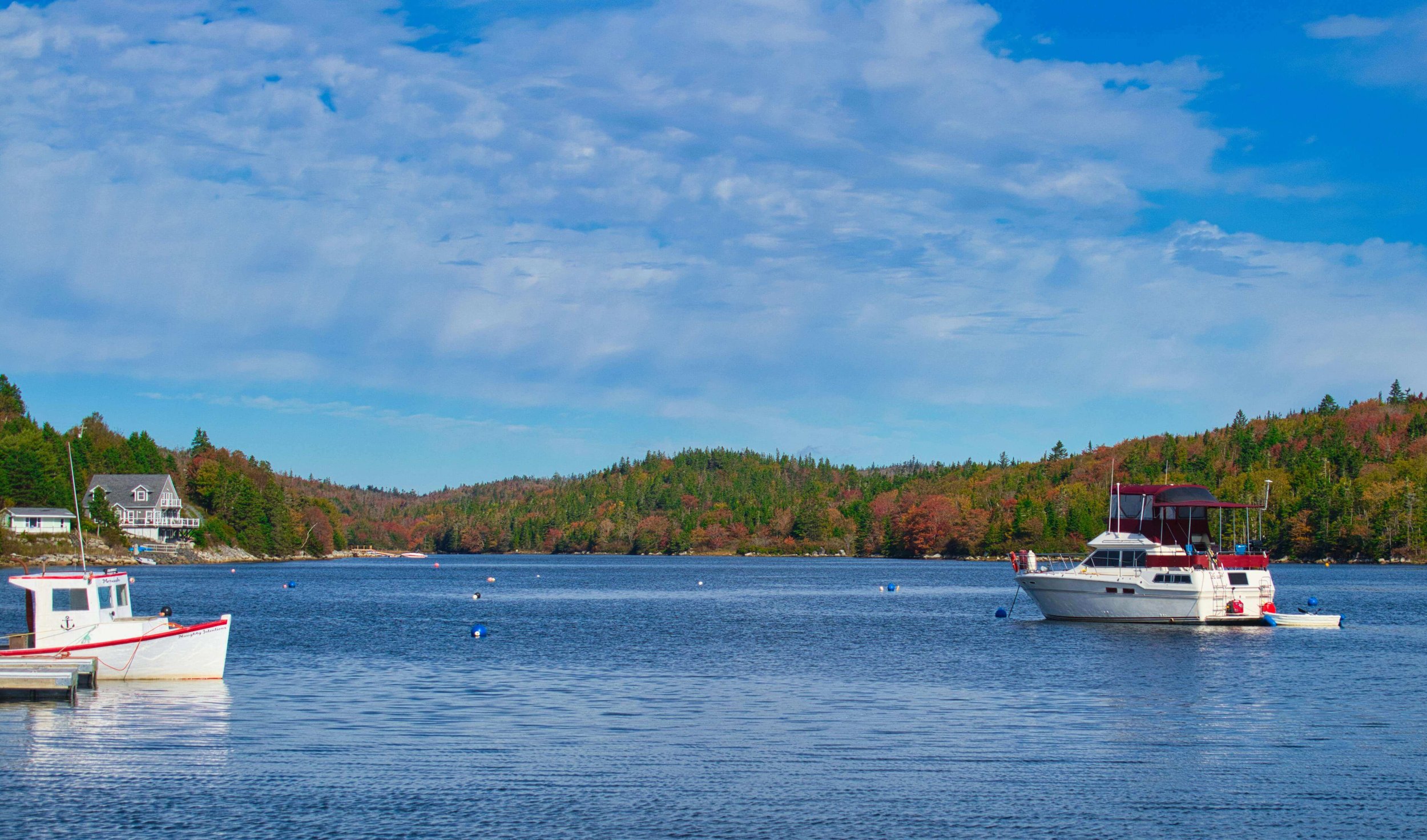 Boats near the Kittery Maine coastline during peak fall foliage season