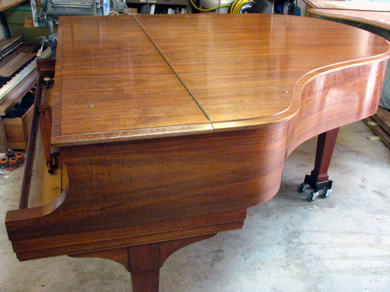 Completed case restoration of walnut Model M. Hand-rubbed clear finish reveals the natural beauty of the walnut veneer, which had previously been concealed beneath an opaque finish. 