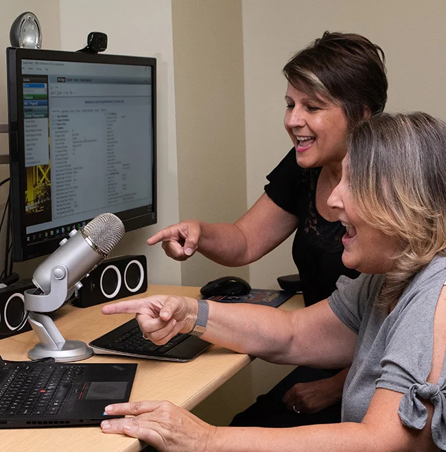 Leslie Bailey, Technical Writer, and Terri Hammond, Training Manager, working together in the Escape studio.