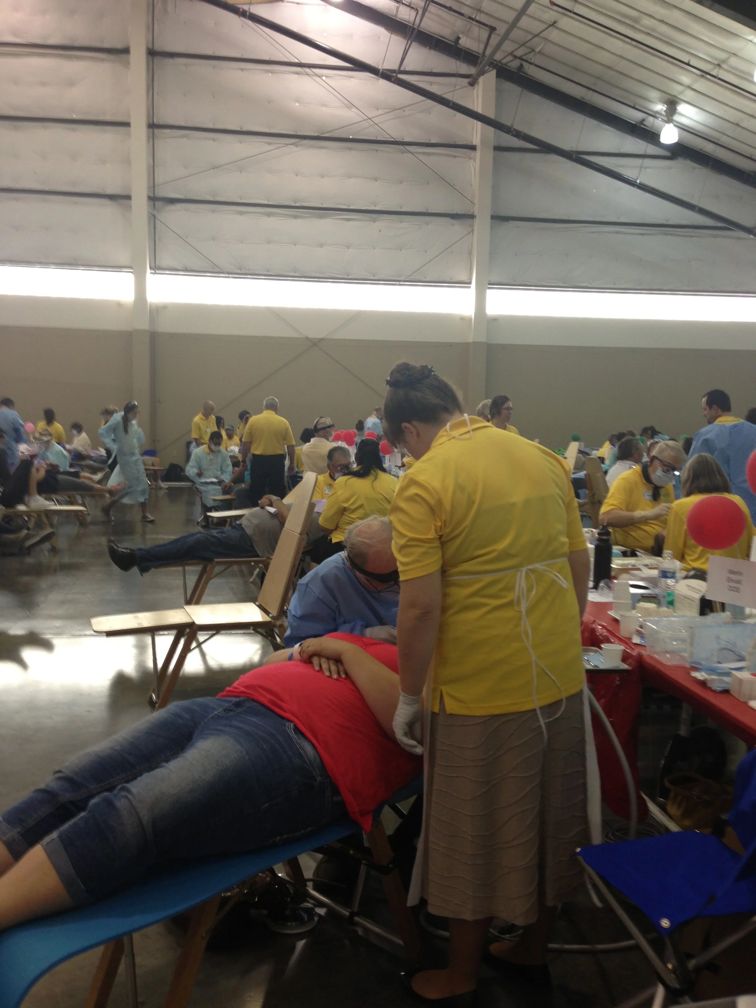 Dentist and volunteer assistant provide care at Pathways to Health 2015.