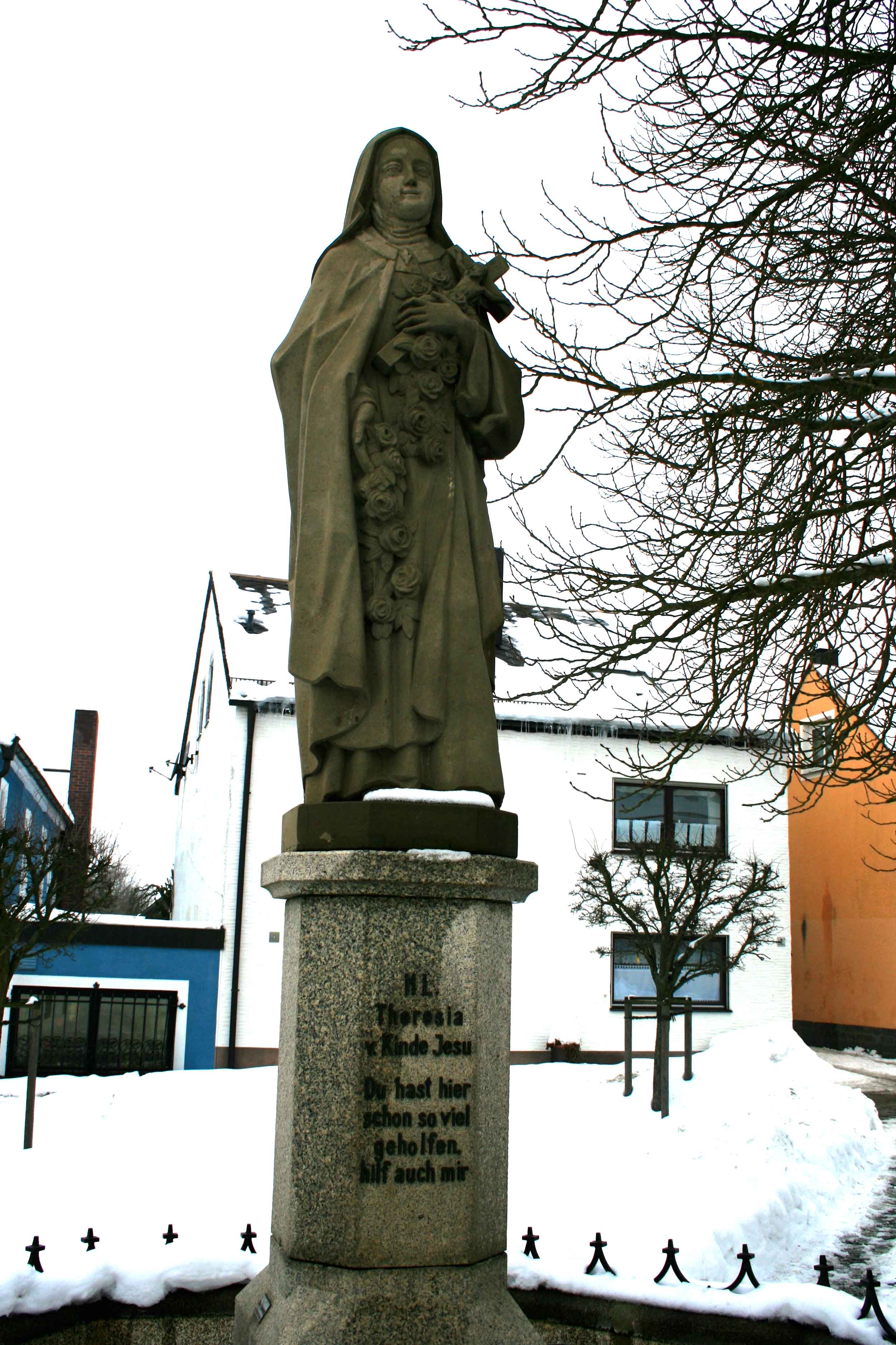 Image©Author, statue of Little Flower of the Child Jesus, Saint Therese of Lisieux, facing the house of Saint Therese Neumann. On the Statue is written in German the prayer of Saint Therese Neumann to the Little Flower-- you have already helped so many, help also me. 