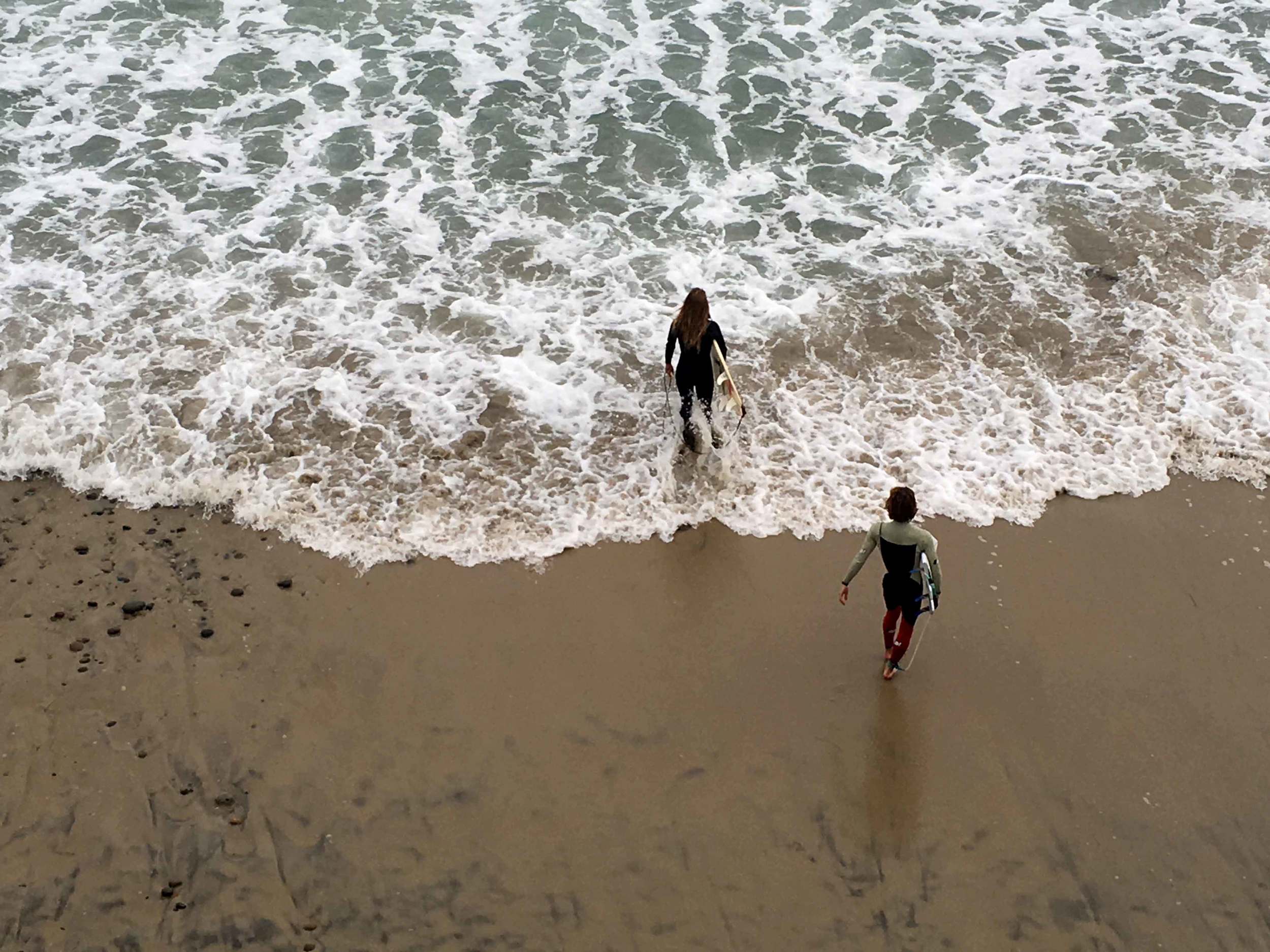 Surfers walking into the ocean, Swamis beach, Encinitas, California. Image©sourcingstyle.com
