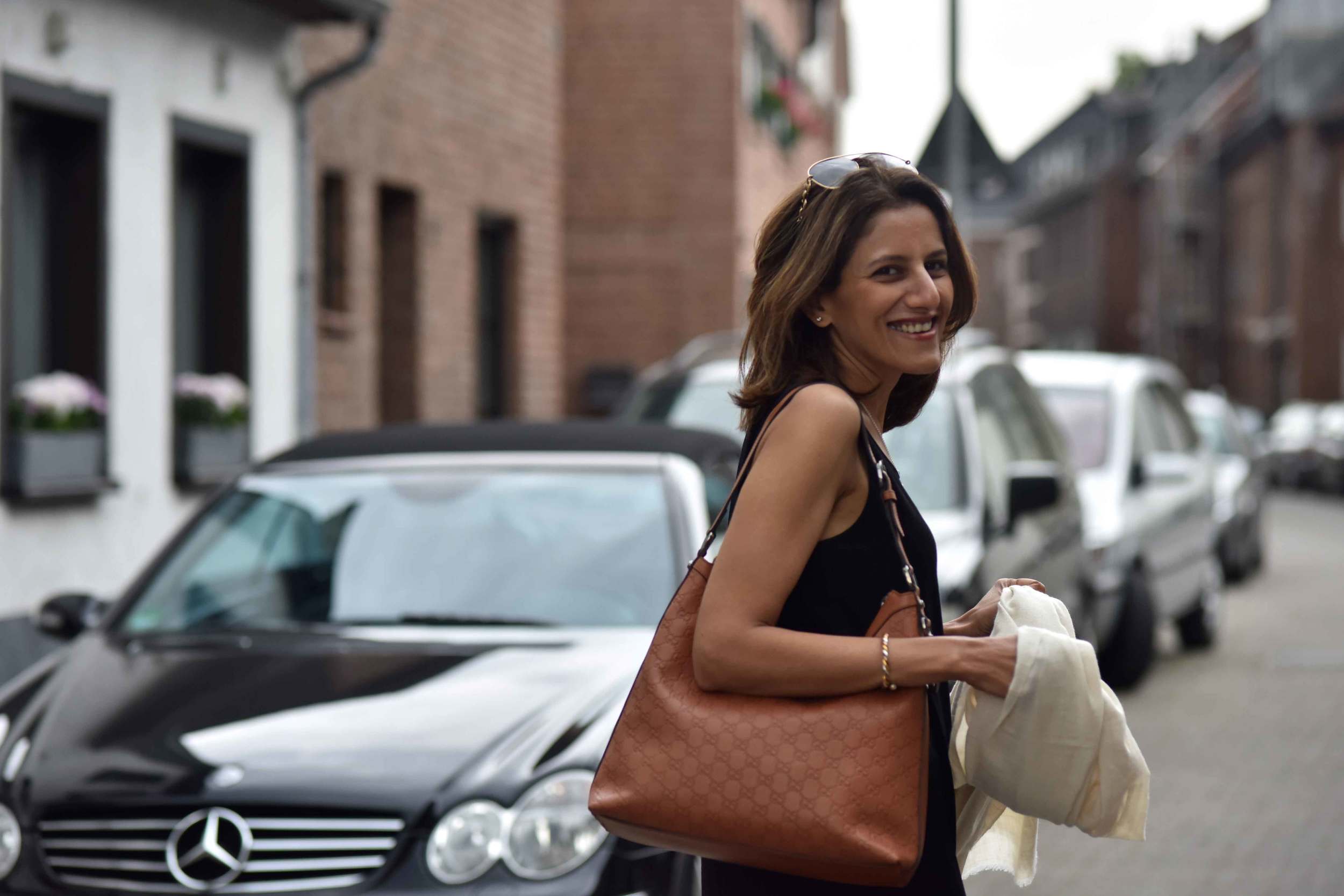 Ready to step out, wearing Eileen Fisher black tank dress in viscose jersey, little black dress, Gucci handbag. Image©sourcingstyle.com, Photo: Nicola Nolting.