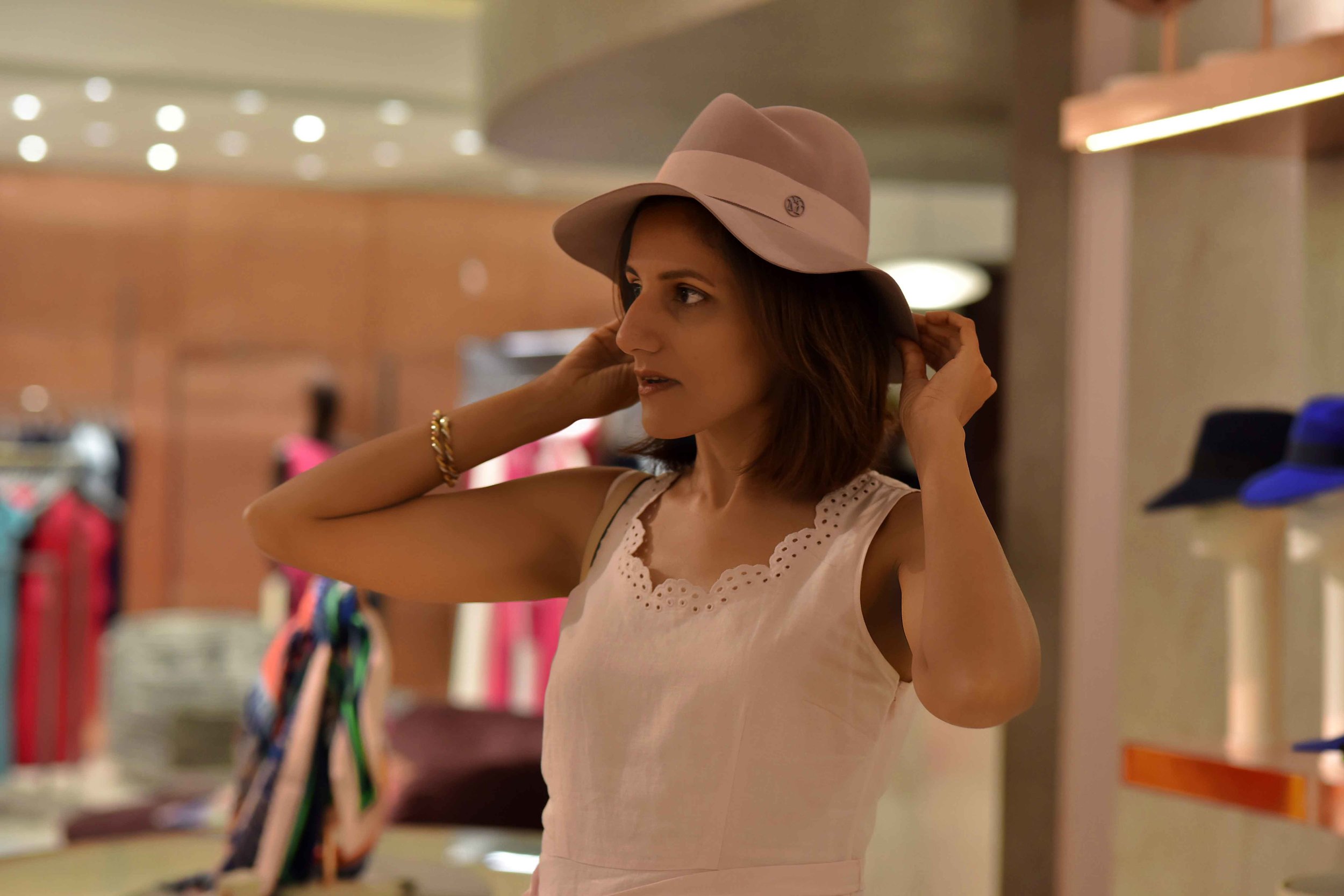 Selfridges, trying out hats, London, U.K. Image©sourcingstyle.com