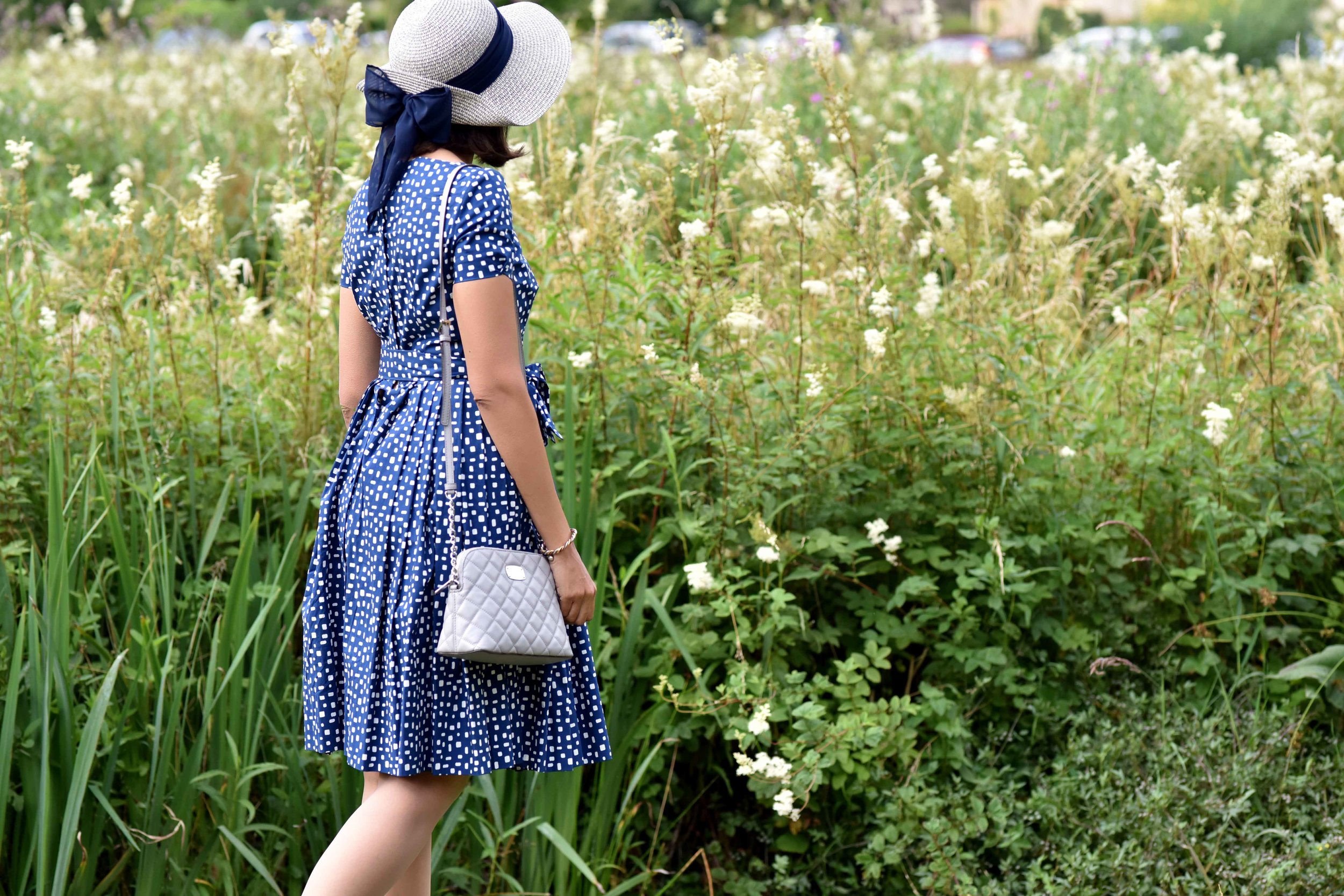 In a Prada dress, Michael Kors bag, Arlington Fields, Bibury, Cotswold, England. Image©sourcingstyle.com