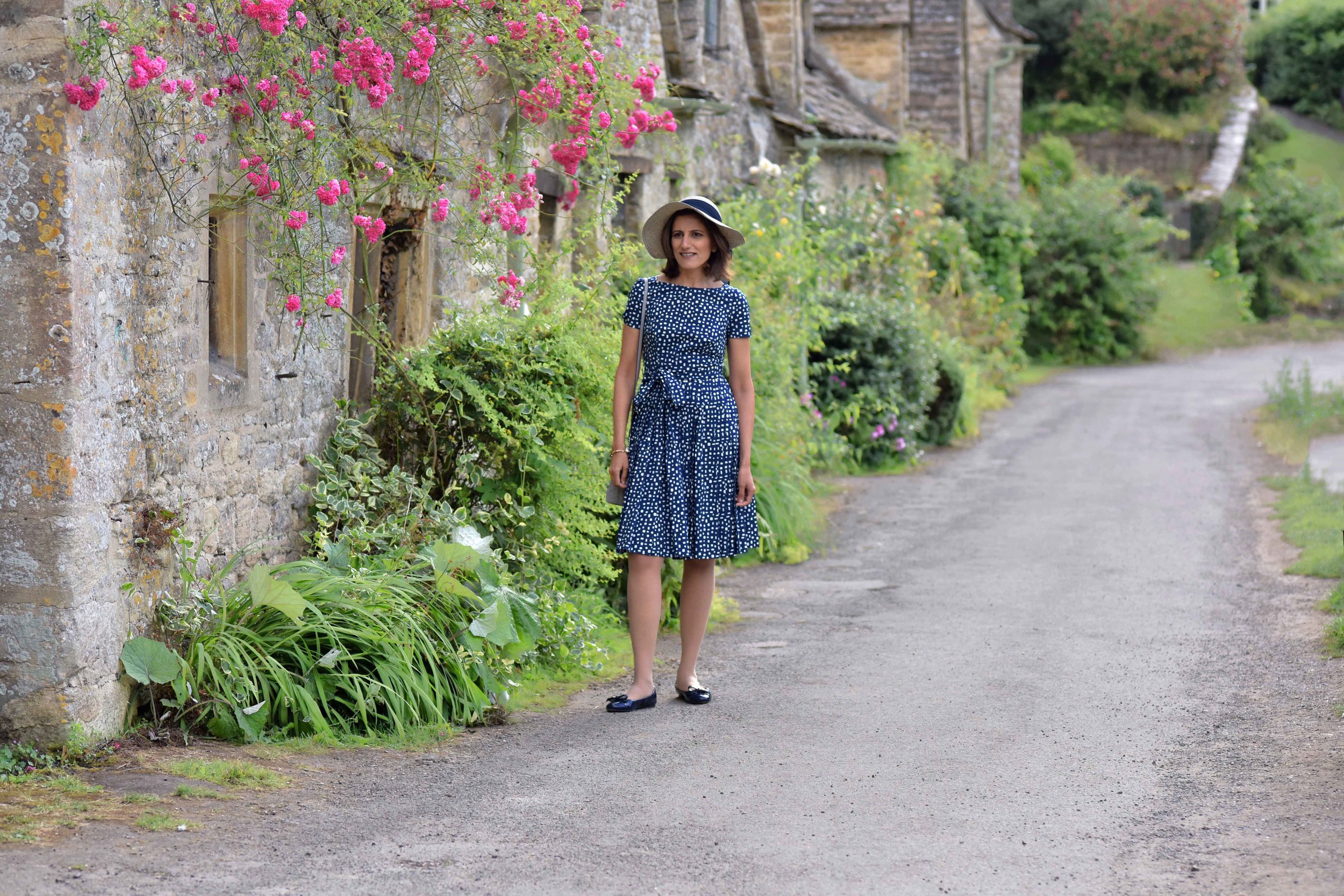 Prada dress, Prada ballet flats, Cotswold stone cottages, Arlington Row, Bibury, Cotswold, England. Image©sourcingstyle.com