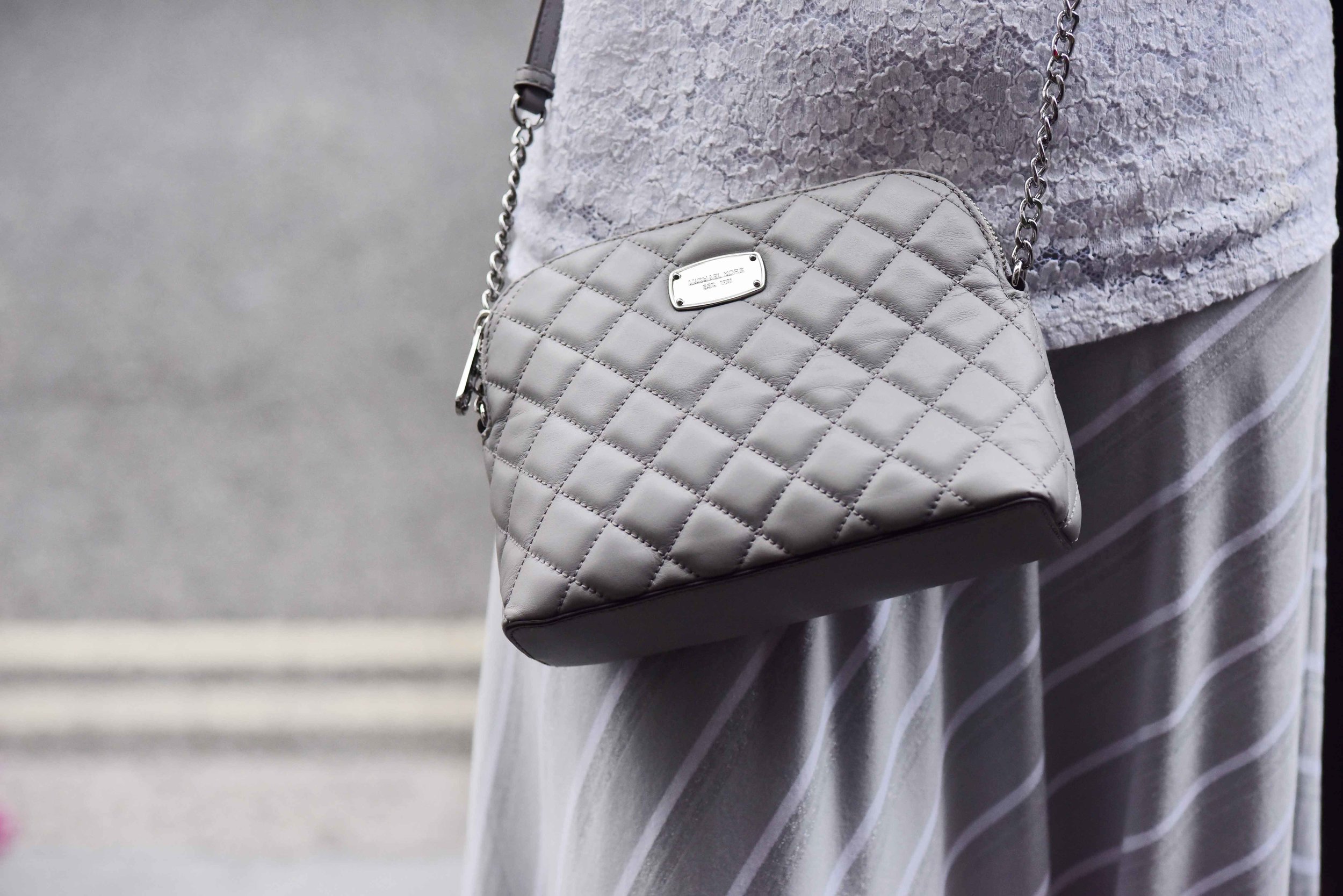 Summer street style, Michael Kors crossbody bag, Marks & Spencer white lace top, Chicos bias cut grey striped skirt. Image©sourcingstyle.com
