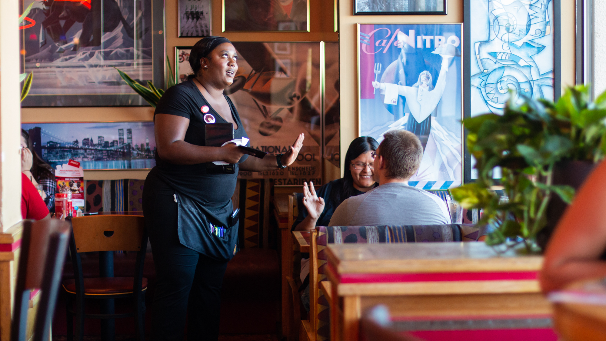  Chiniqua Bright jokes with a customer while waiting tables at Red Robin on Sept. 29, 2018. Beginning as a server at the restaurant, Bright quickly advanced to bartender and lead trainer.  