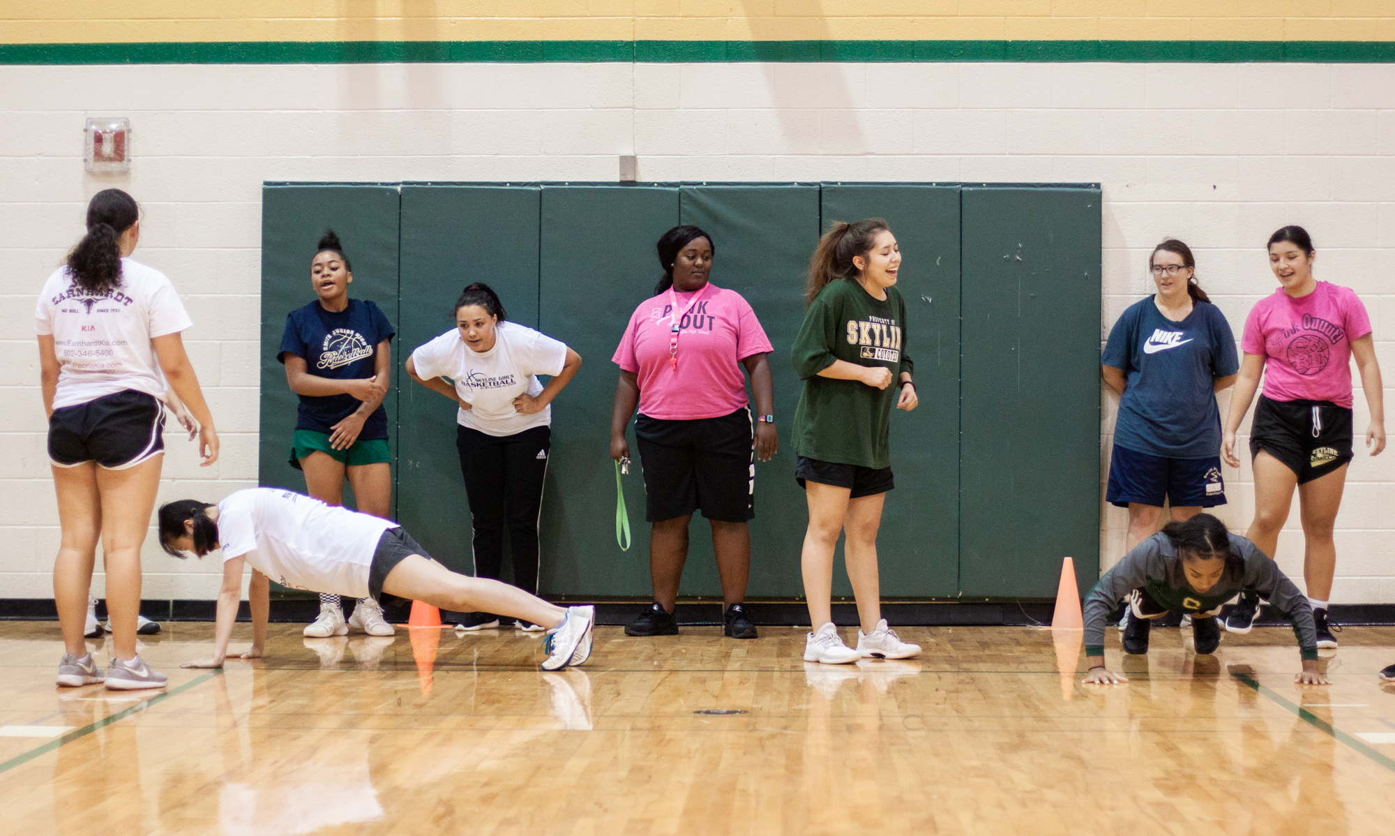  Chiniqua Bright looks on as her students, all members of Skyline’s female varsity basketball team, participate in a relay push-up exercise on Oct. 3, 2018. Skyline is a Title 1 high school, meaning at least 40 percent of the student body comes from 