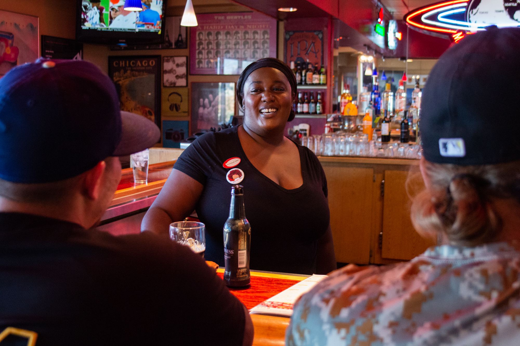  Chiniqua Bright shares a laugh with two regular customers at the bar on Sept. 29, 2018. Although her schedule fluctuates during basketball season, she regularly picks up shifts, and her manager said he trusts her with the keys to the restaurant. 