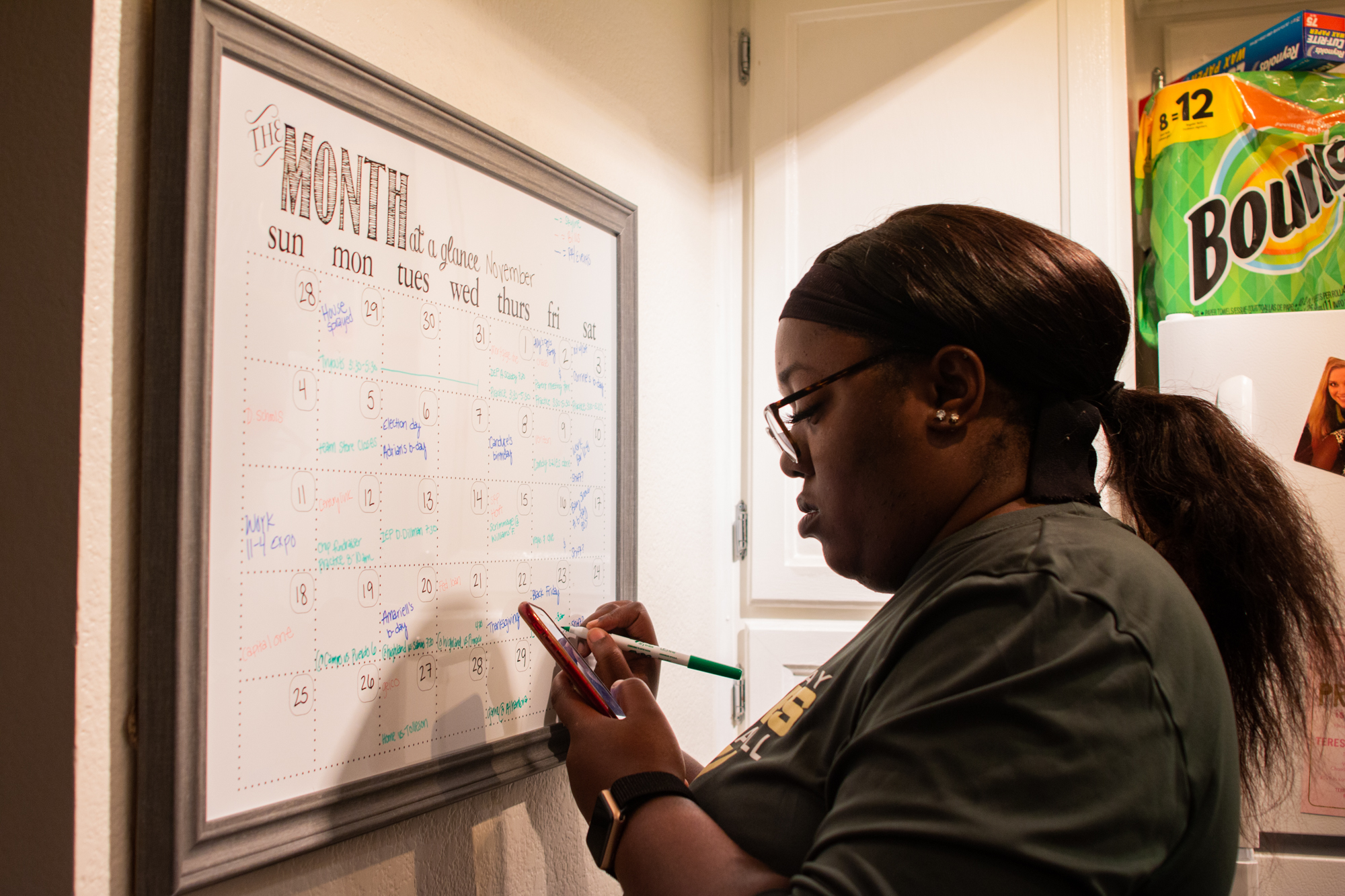  Chiniqua Bright adds items to her calendar early in the morning on Nov. 15, 2018. She said the calendar helps keep all of her obligations straight. In addition to coaching practices and attending games, she frequently attends Individualized Educatio