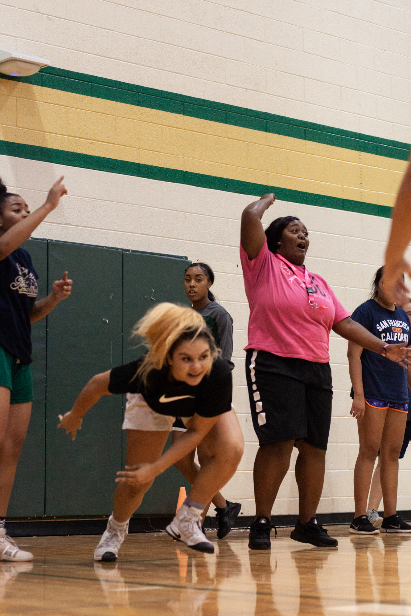  Chiniqua Bright cheers on her varsity basketball students during a relay warm-up on Oct. 3, 2018. It was too sweltering hot to go outside and run that day, but Bright insisted her students run anyway. 