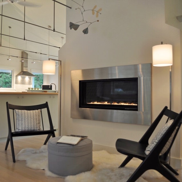 The pillows in front of the linear gas fireplace are not far from the dining alcove and pick up on the same grey “Ripple Effect” pattern that’s on the valence there. The grey works well with the stainless fireplace surround, so we chose a similar gray for the hemp/organic cotton fabric on the reupholstered ottoman.